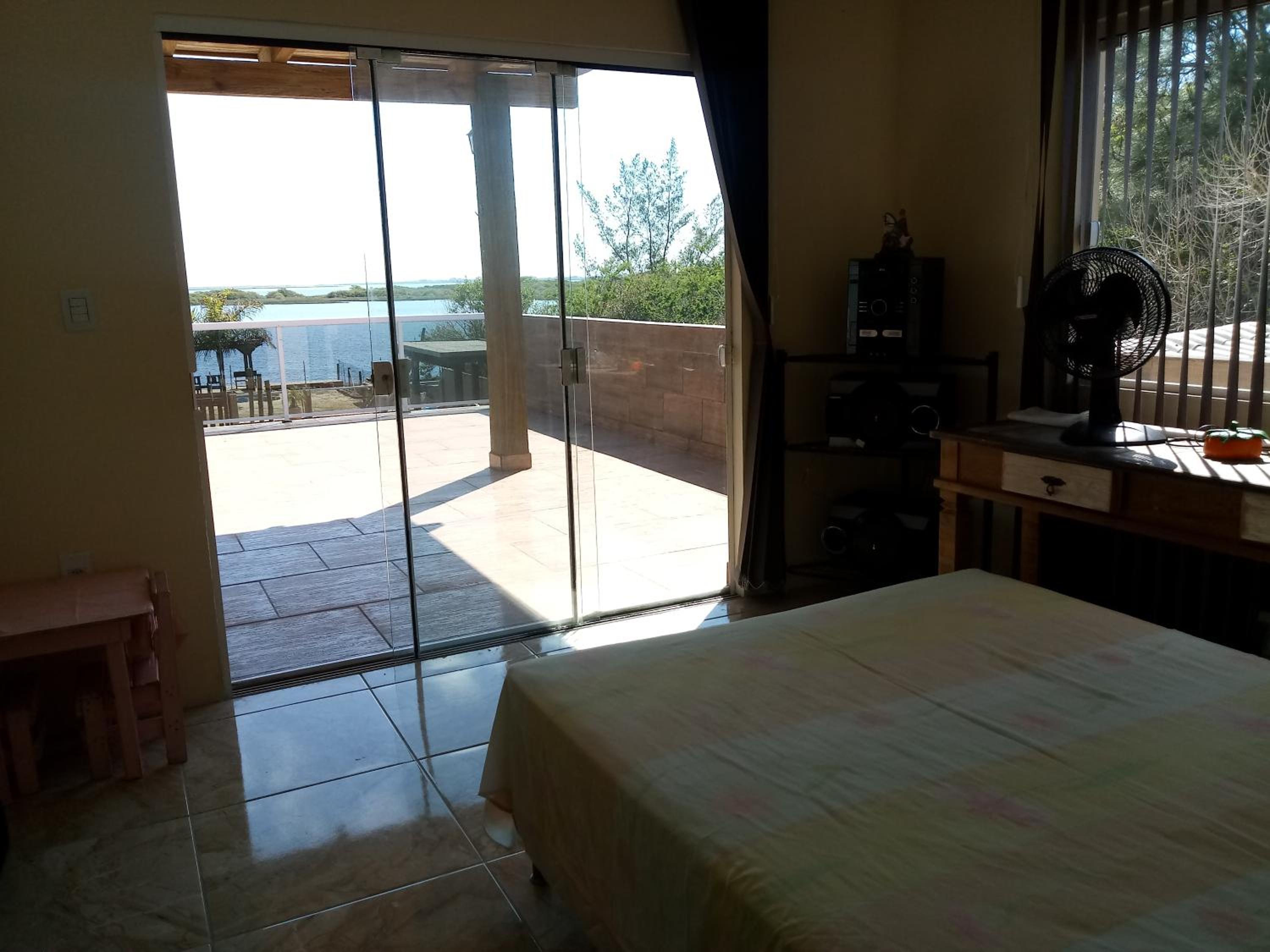 Casa na beira da lagoa com piscina e rampa para embarcações