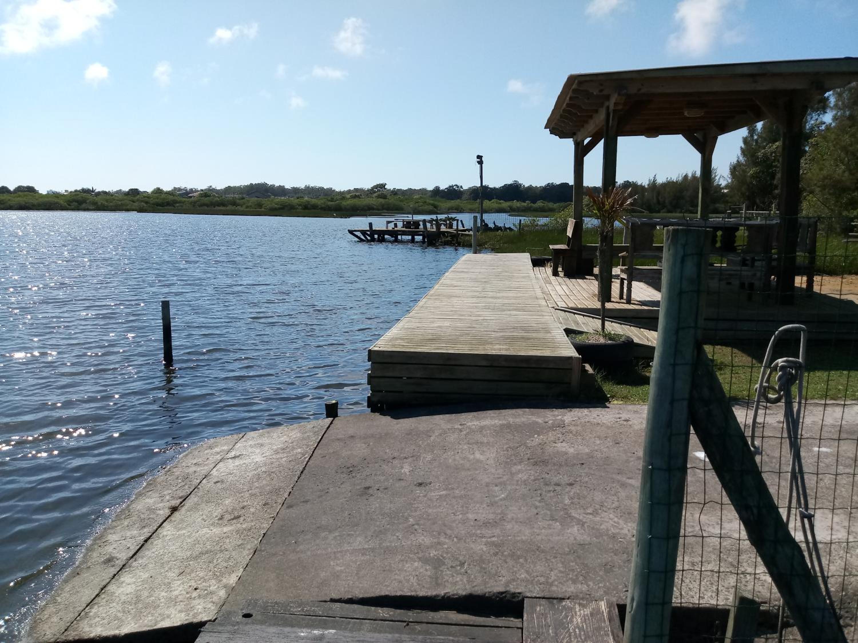 Casa na beira da lagoa com piscina e rampa para embarcações