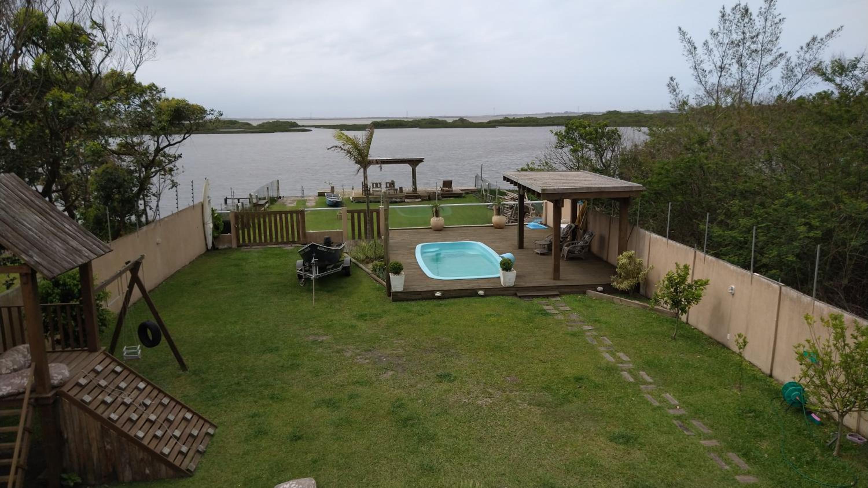 Casa na beira da lagoa com piscina e rampa para embarcações