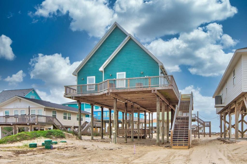 Martinis & Bikinis, a beach front house with toes in the sand drink in the hand. view 5