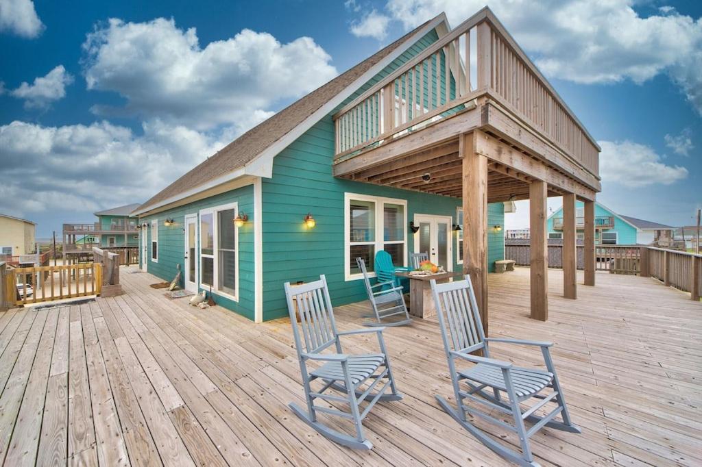 Martinis & Bikinis, a beach front house with toes in the sand drink in the hand. view 3