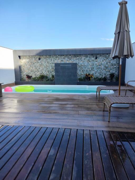 Sobrado com piscina, banheira e garagem coberta.