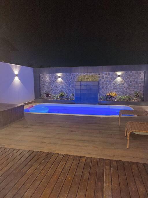 Sobrado com piscina, banheira e garagem coberta.