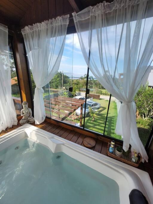 Casa de frente para Lagoa de Ibiraquera com piscina e banheira