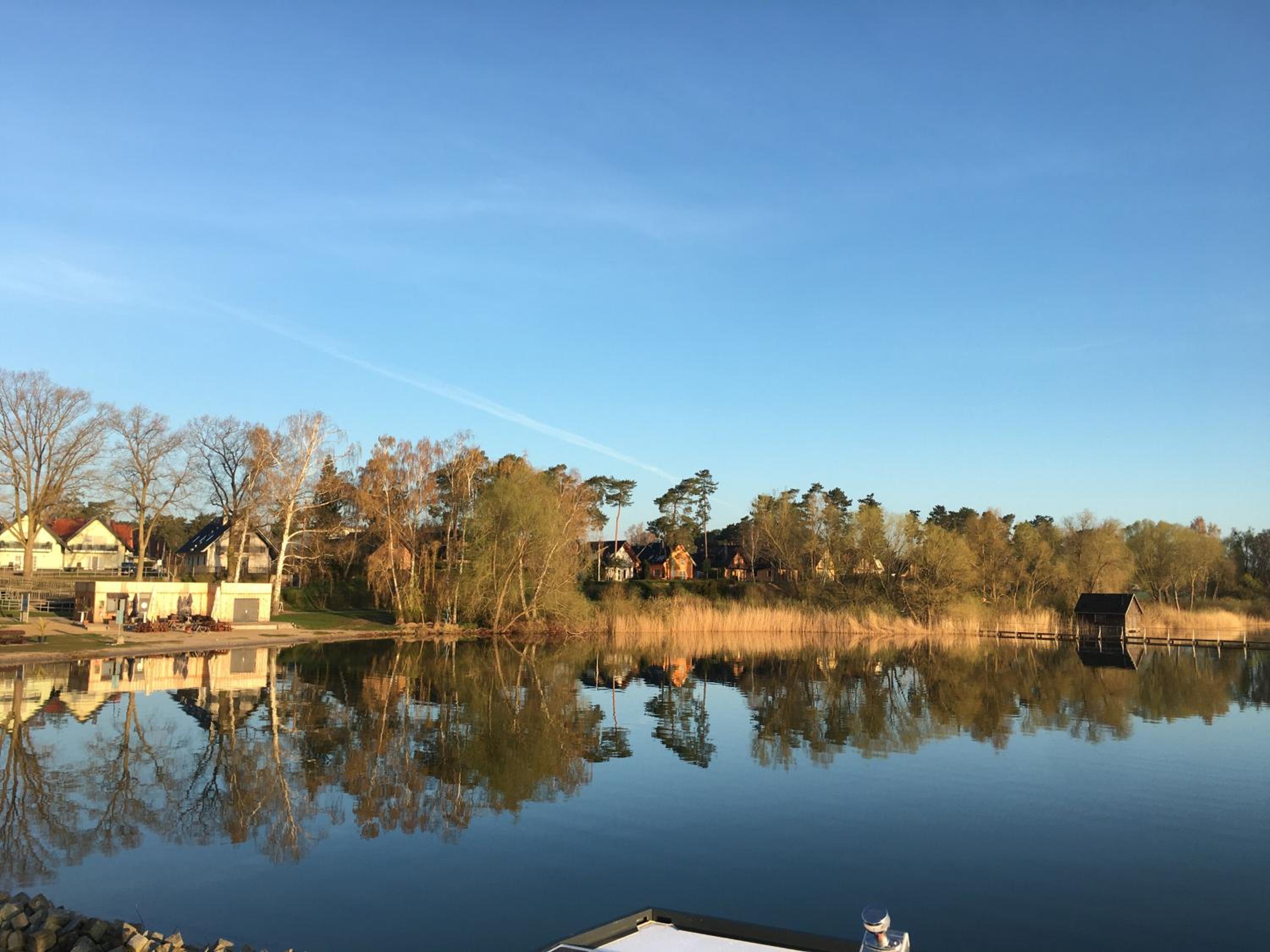 Modernes festliegendes Hausboot mit großzügiger Dachterrasse und Ruderboot