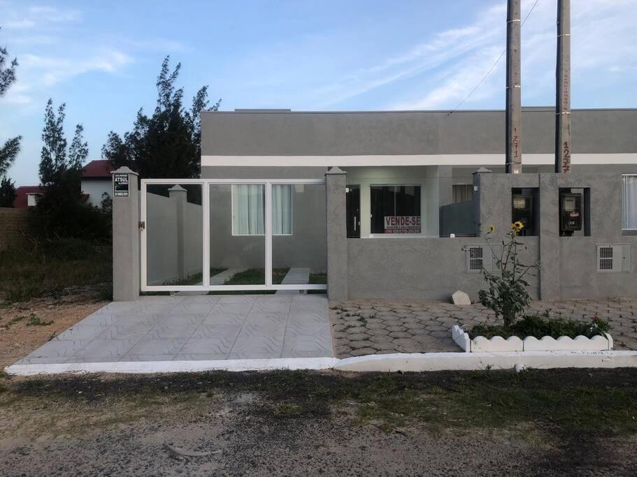 Casa em Atlântida Sul, com 2 quartos e 2 banheiros, com ar condicionado.
