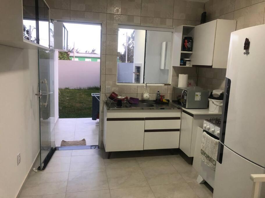 Casa em Atlântida Sul, com 2 quartos e 2 banheiros, com ar condicionado.