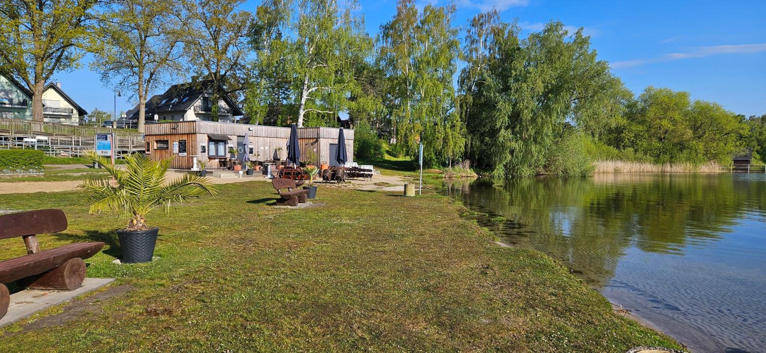 Modernes festliegendes Hausboot mit großzügiger Dachterrasse und Ruderboot
