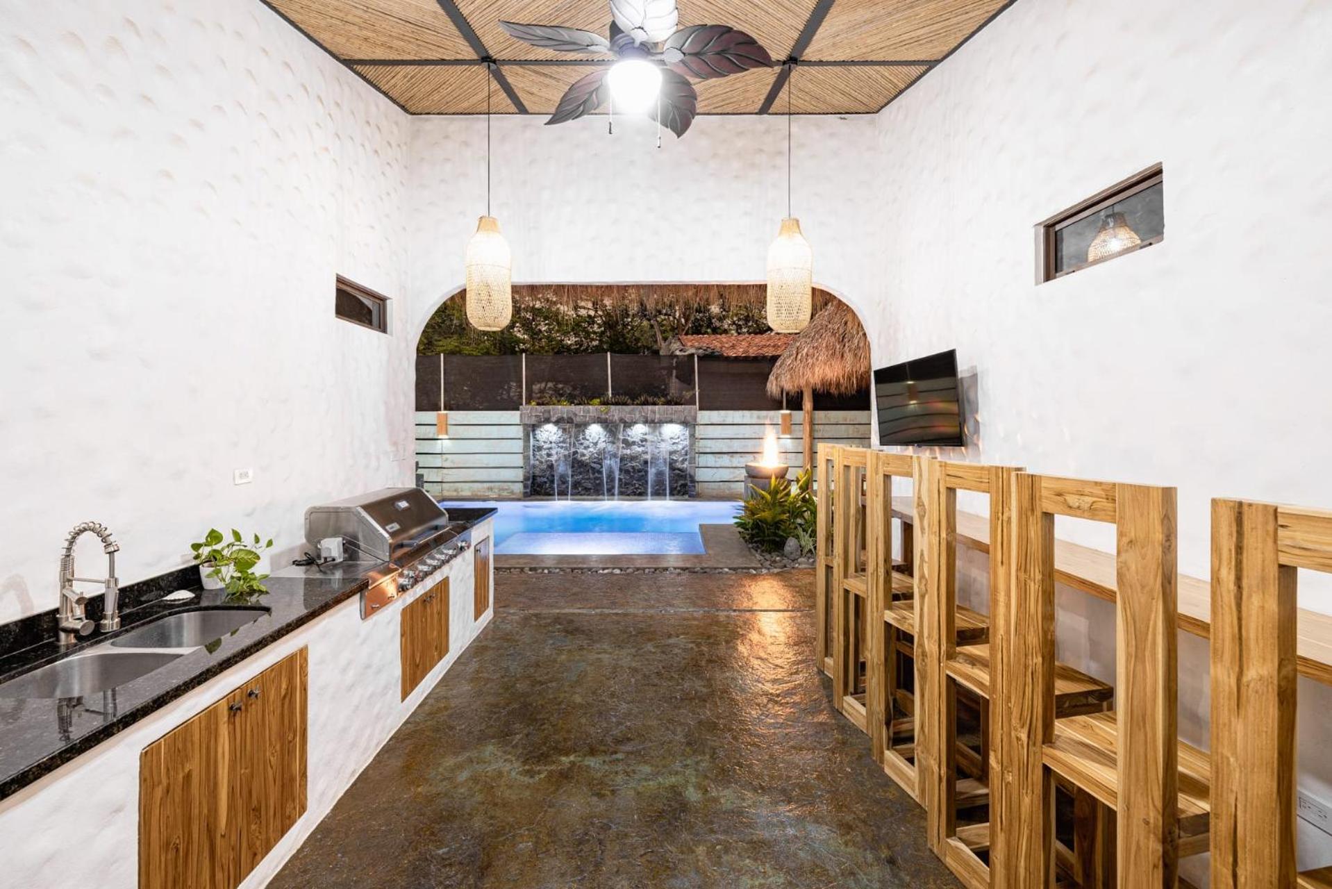 Modern Home with Chic Bohemian Style and Zen Outdoor Oasis with Swimming Pool and Tiki Style Dining Space