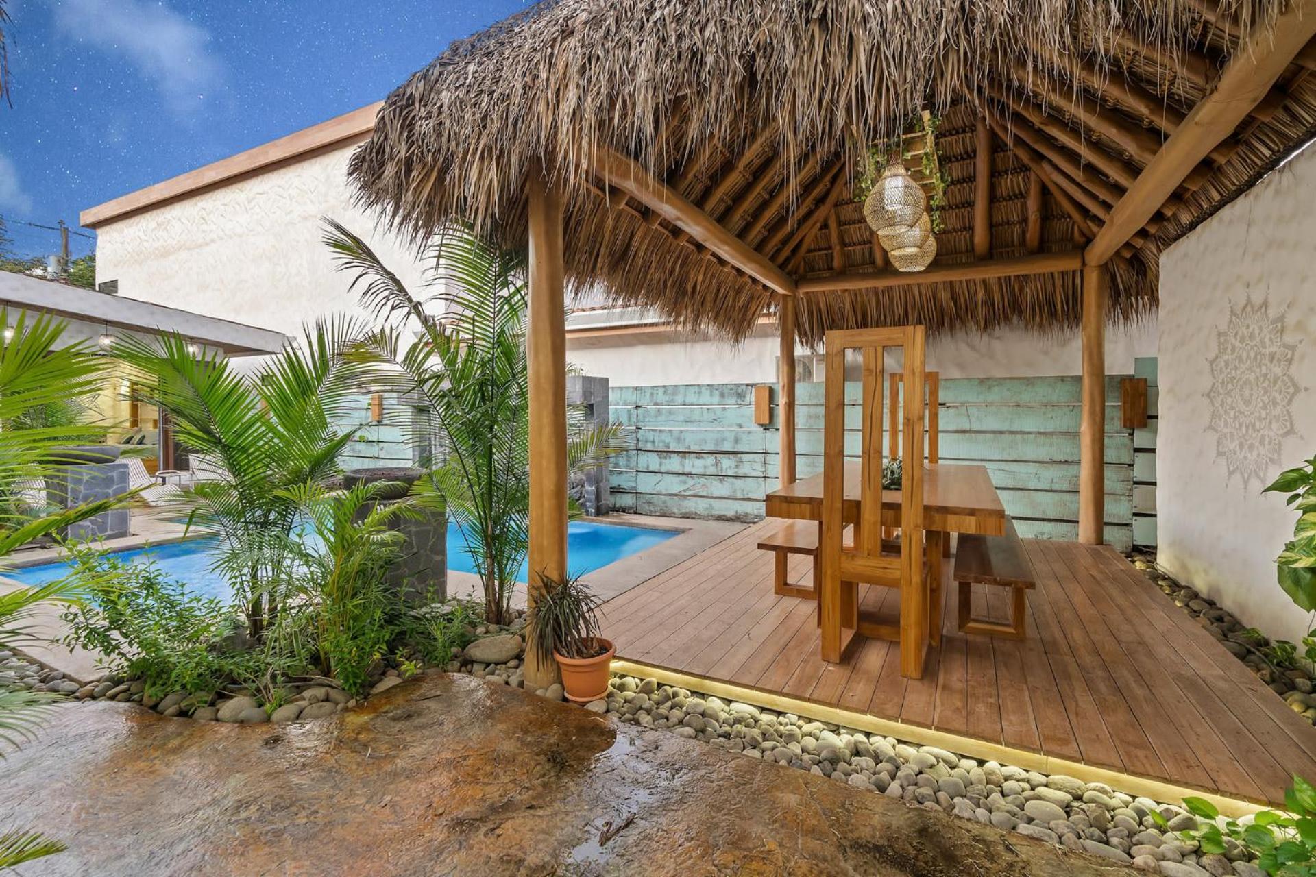 Modern Home with Chic Bohemian Style and Zen Outdoor Oasis with Swimming Pool and Tiki Style Dining Space