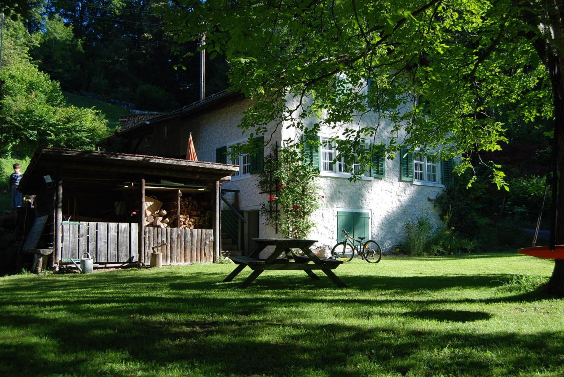 Bergbauernhaus an Wasserfall und Waldrand