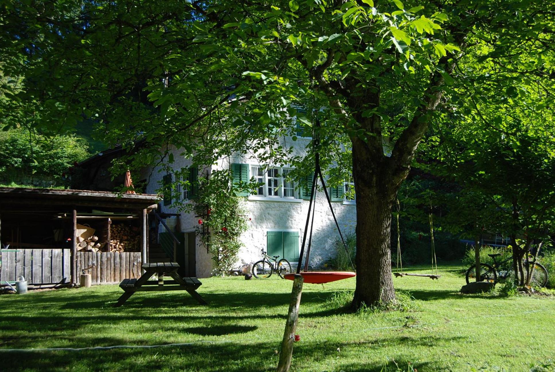 Bergbauernhaus an Wasserfall und Waldrand