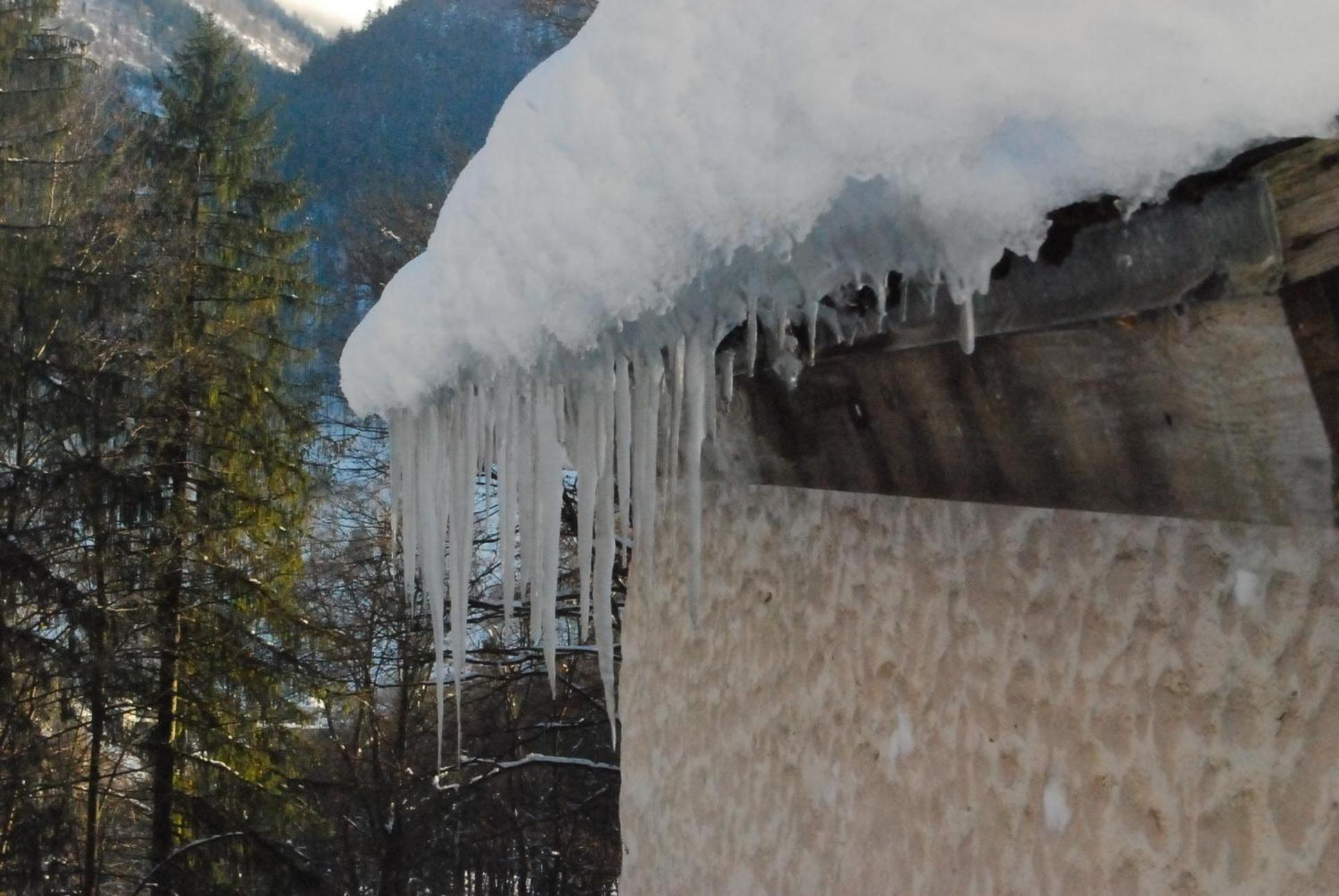 Bergbauernhaus an Wasserfall und Waldrand