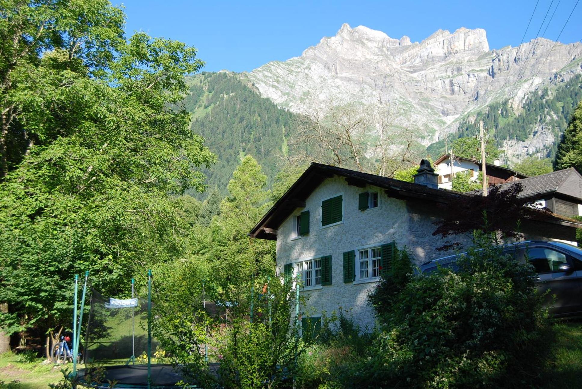 Bergbauernhaus an Wasserfall und Waldrand