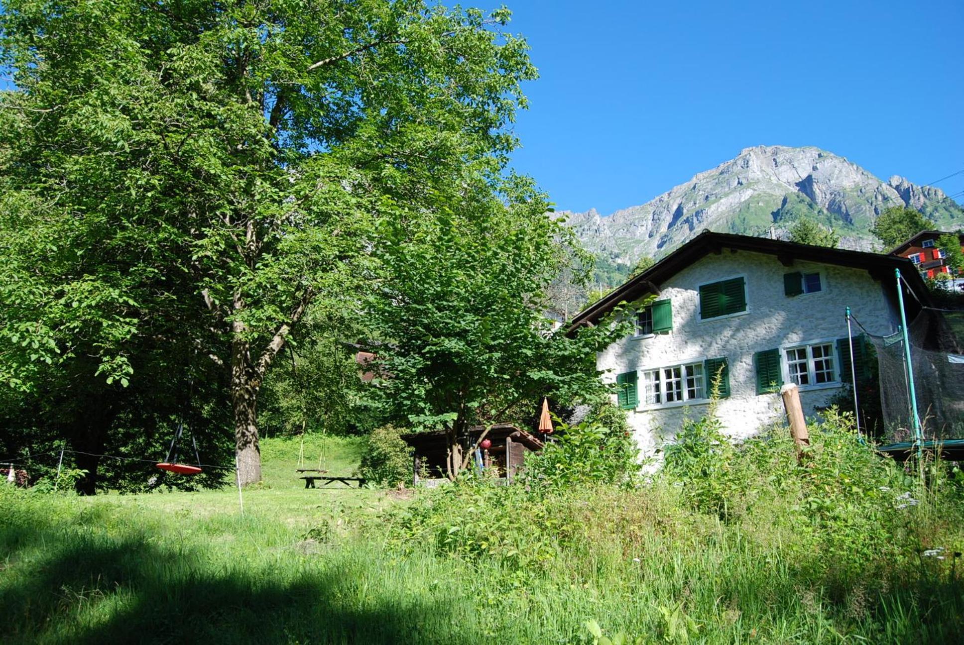 Bergbauernhaus an Wasserfall und Waldrand