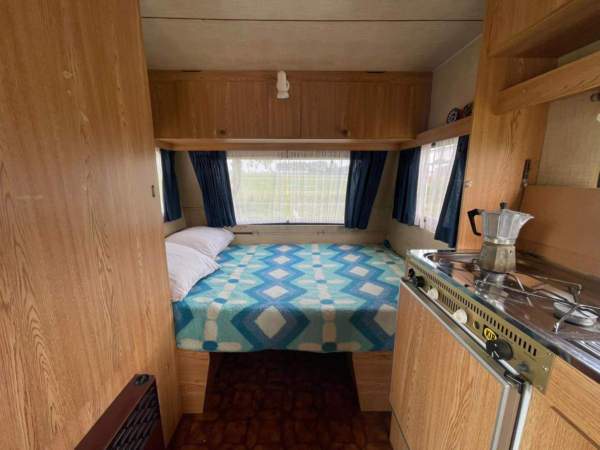 Vintage caravan in old orchard at farm Huize Blokland
