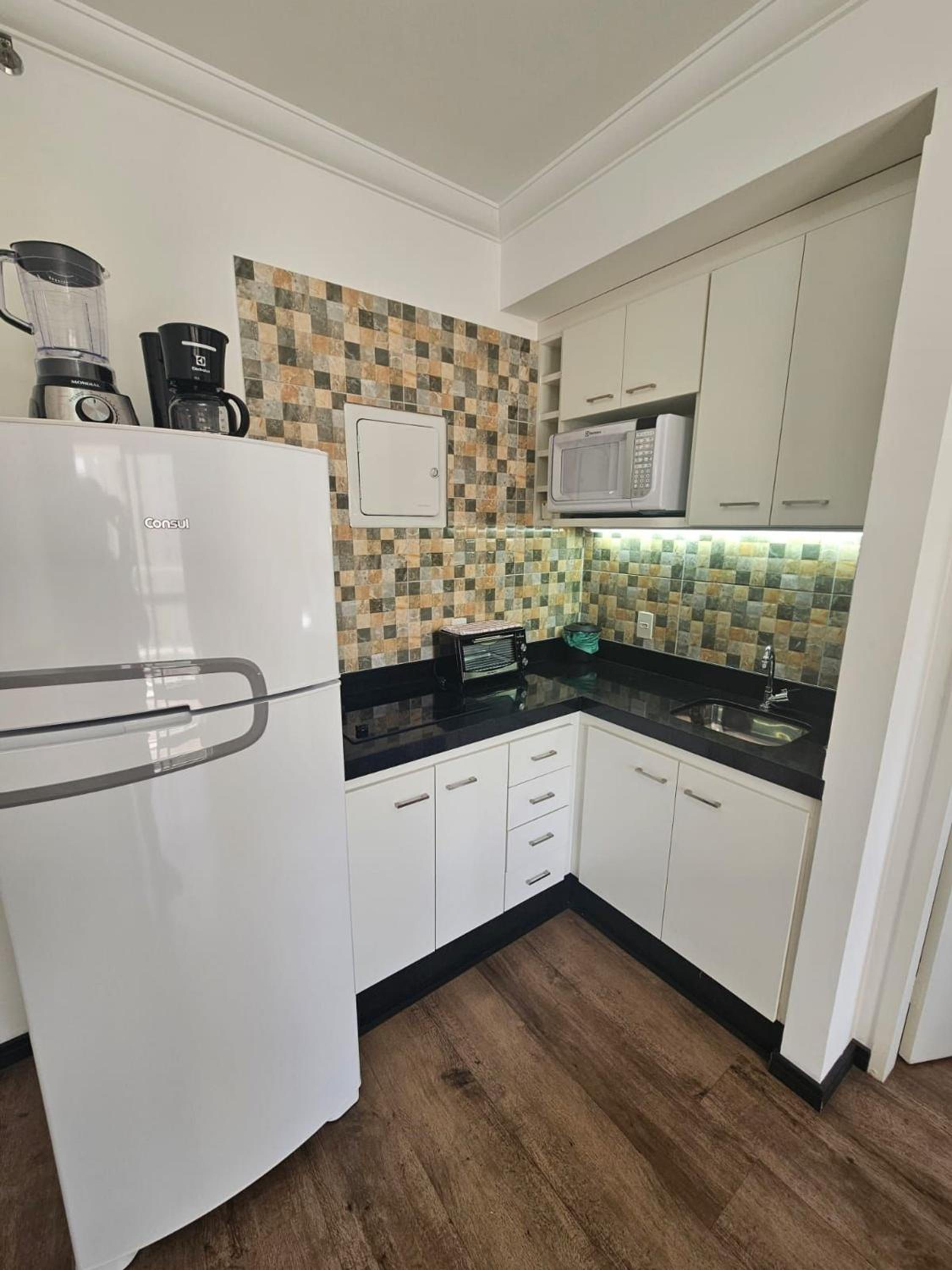 Flat Hotel The Palace com quarto sala e cozinha