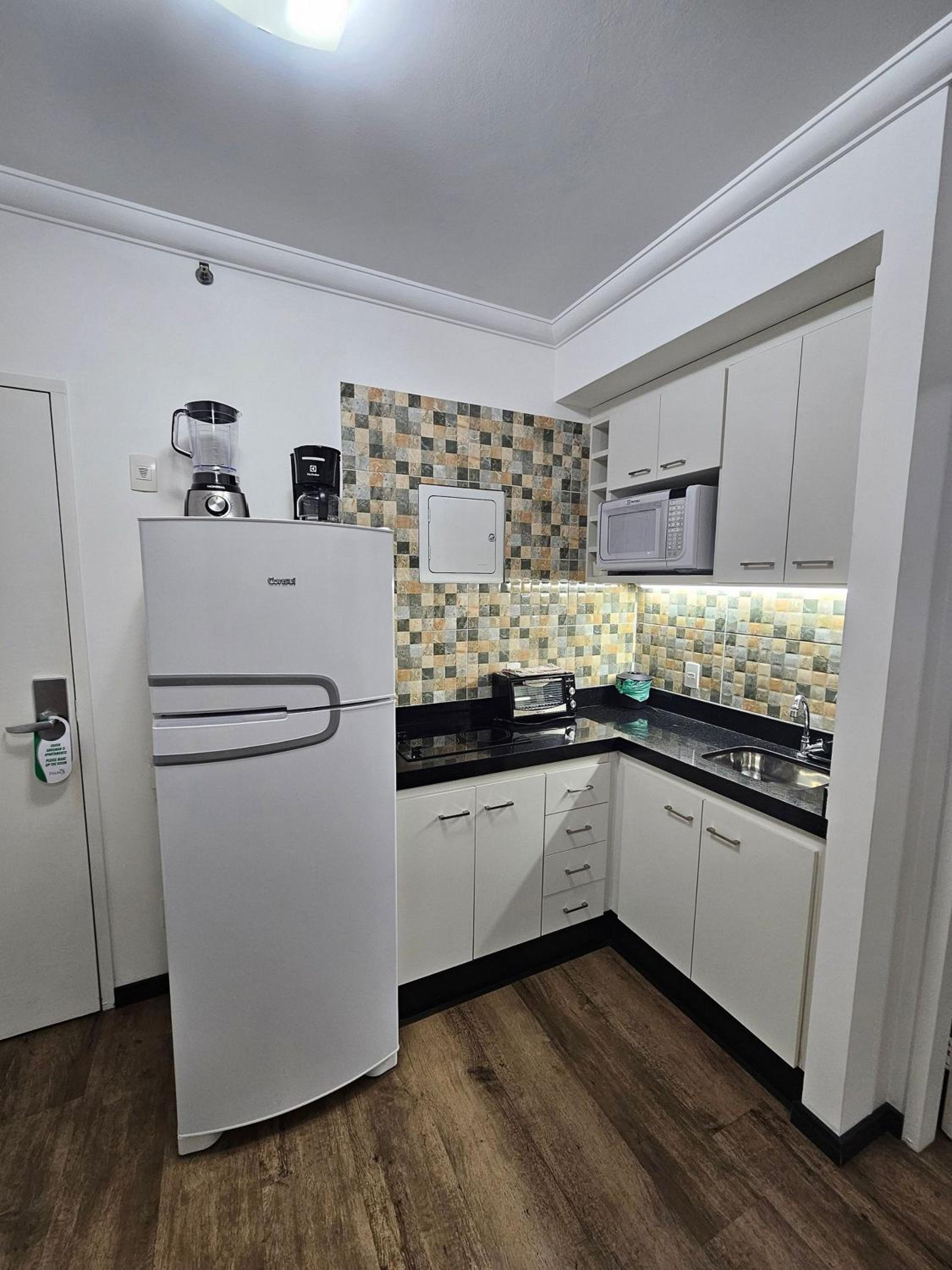 Flat Hotel The Palace com quarto sala e cozinha