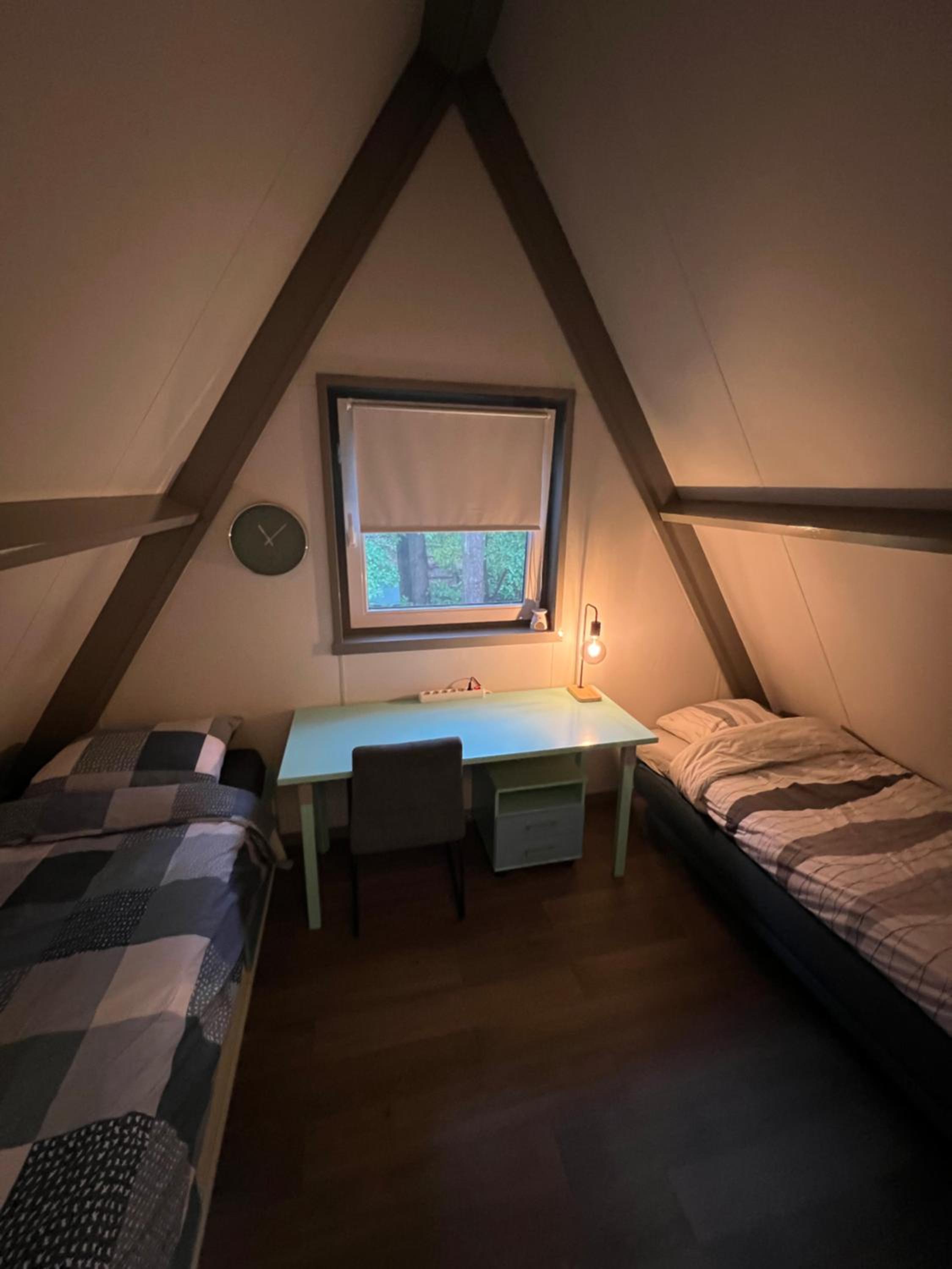Dennenrust A-frame huisje middenin het bos.