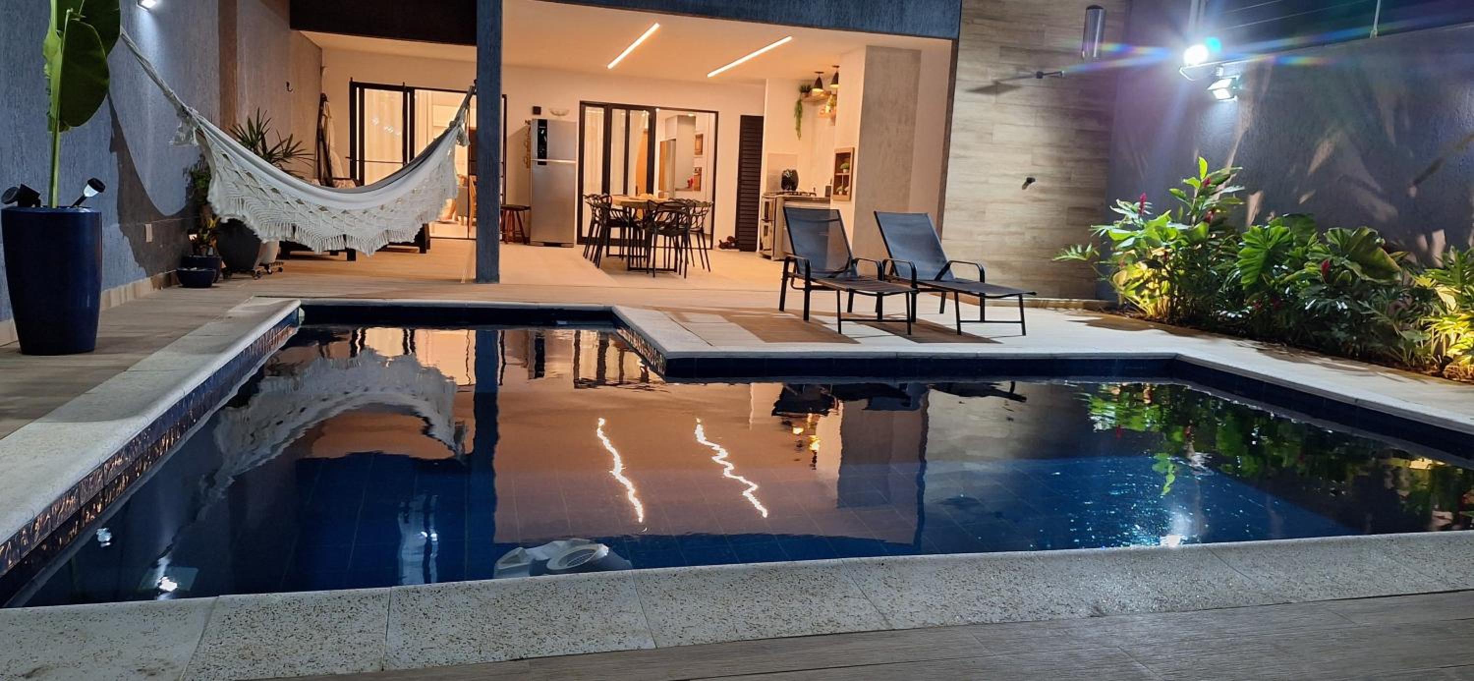 Suíte tripla com vista piscina em casa familiar de luxo em Itaipu