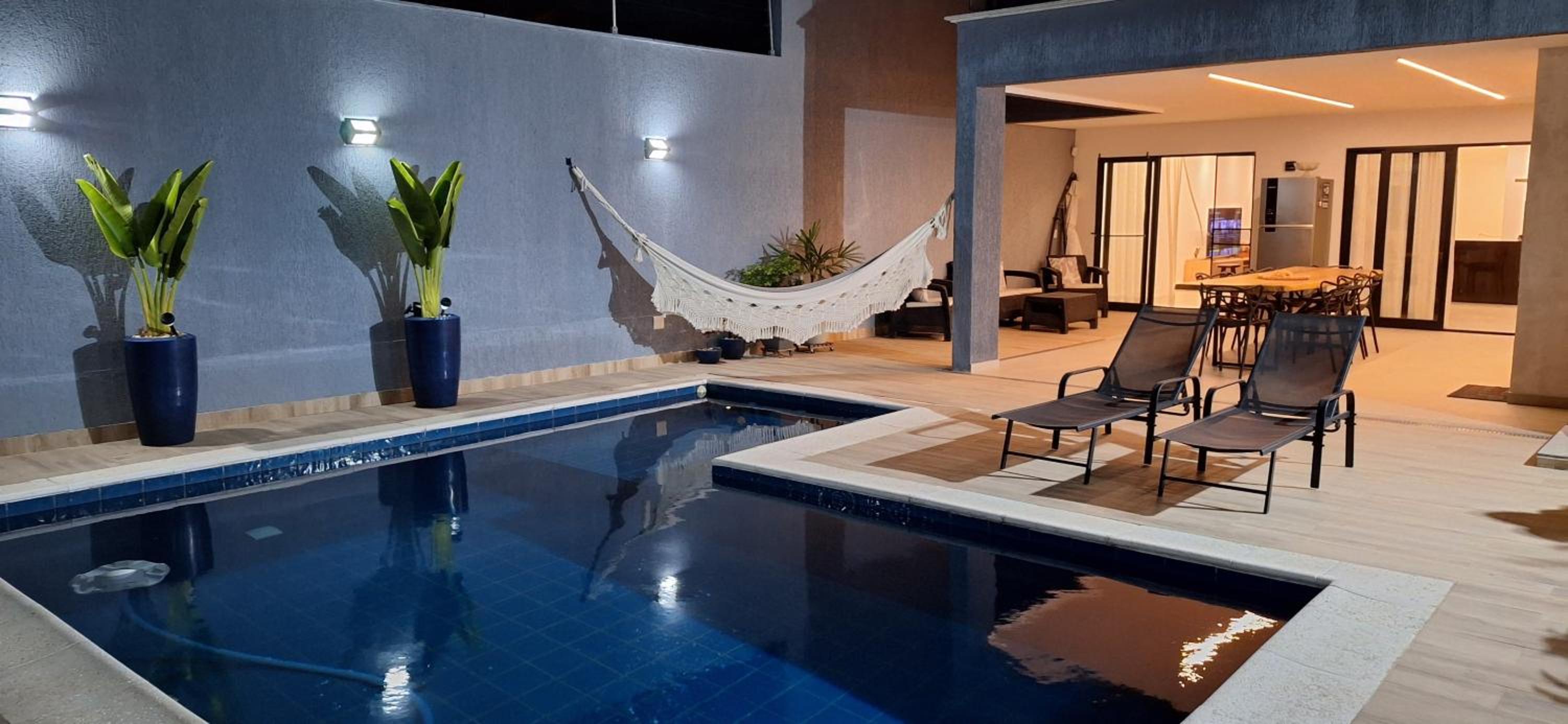 Suíte tripla com vista piscina em casa familiar de luxo em Itaipu