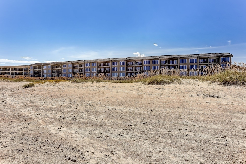 Coast View Condo Featuring Large Windows Overlooking the Beach by RedAwning