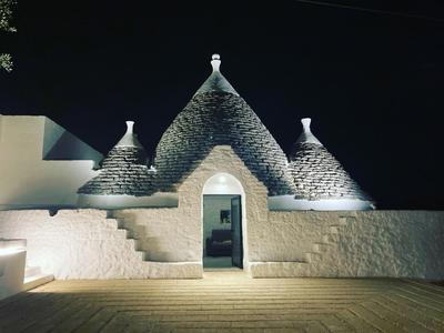 Trulli au milieu d'un champ d'oliviers avec piscine