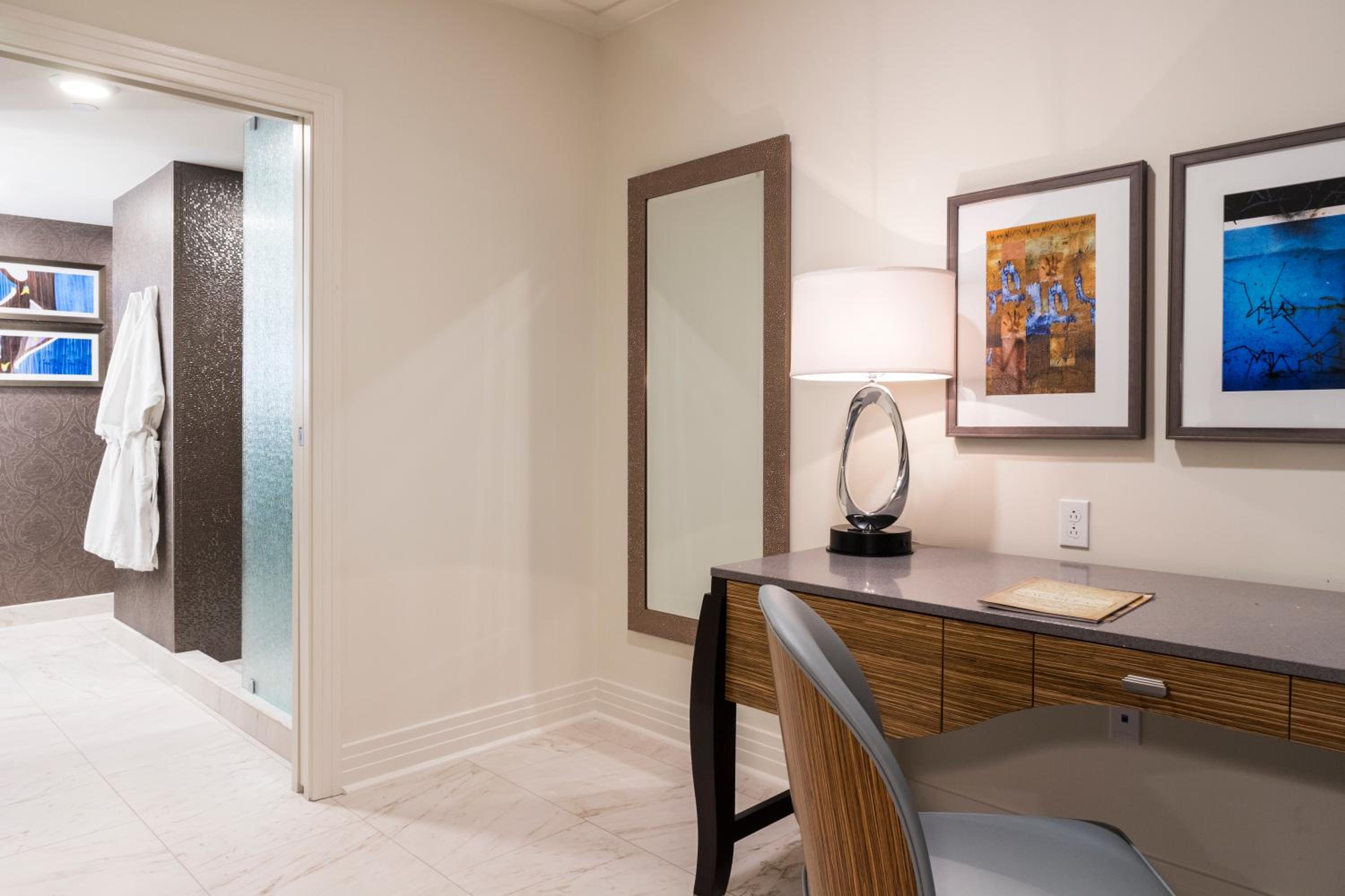 Hotel room desk with chair, lamp, and mirror