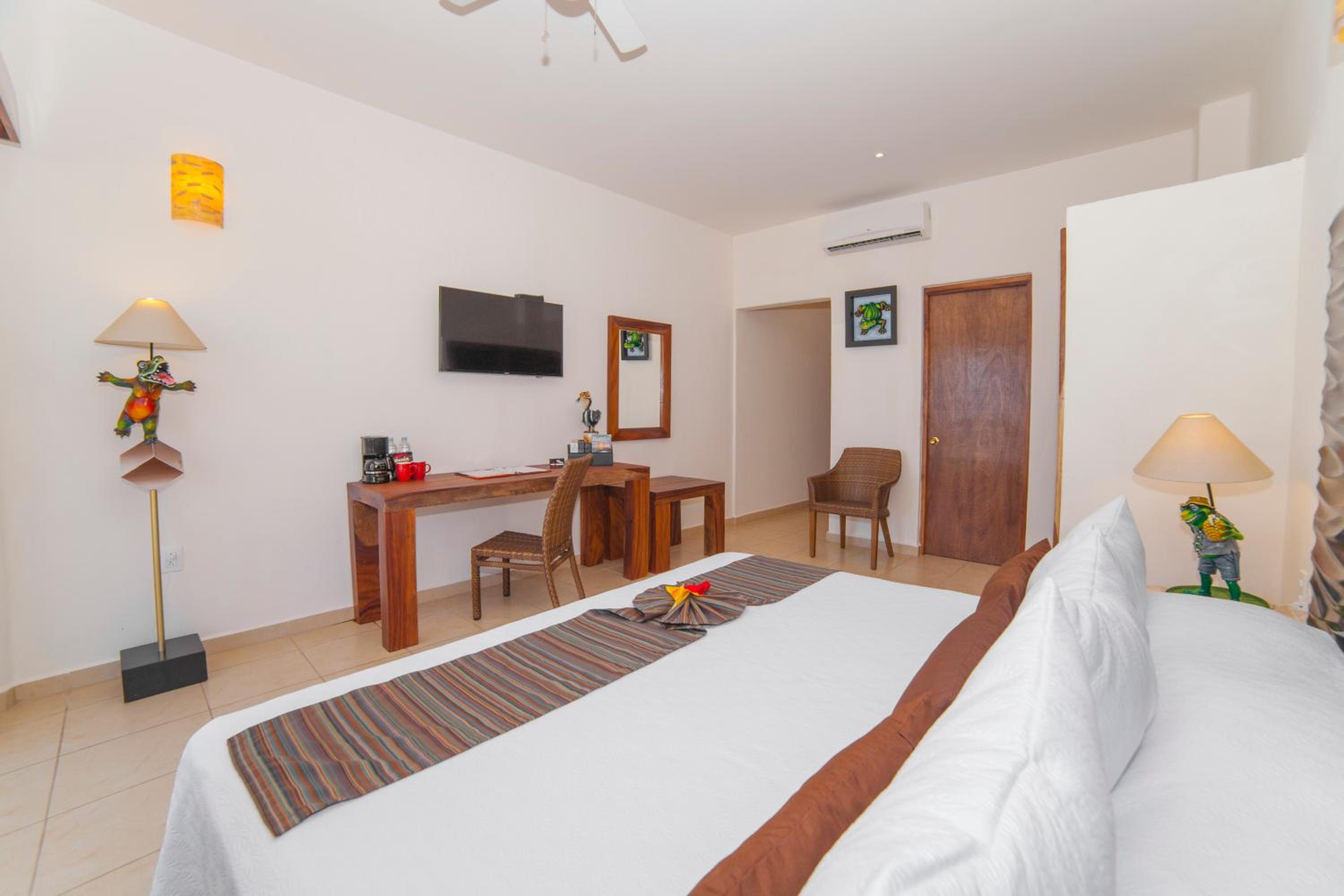 Habitación King con vista parcial al mar y balcón.