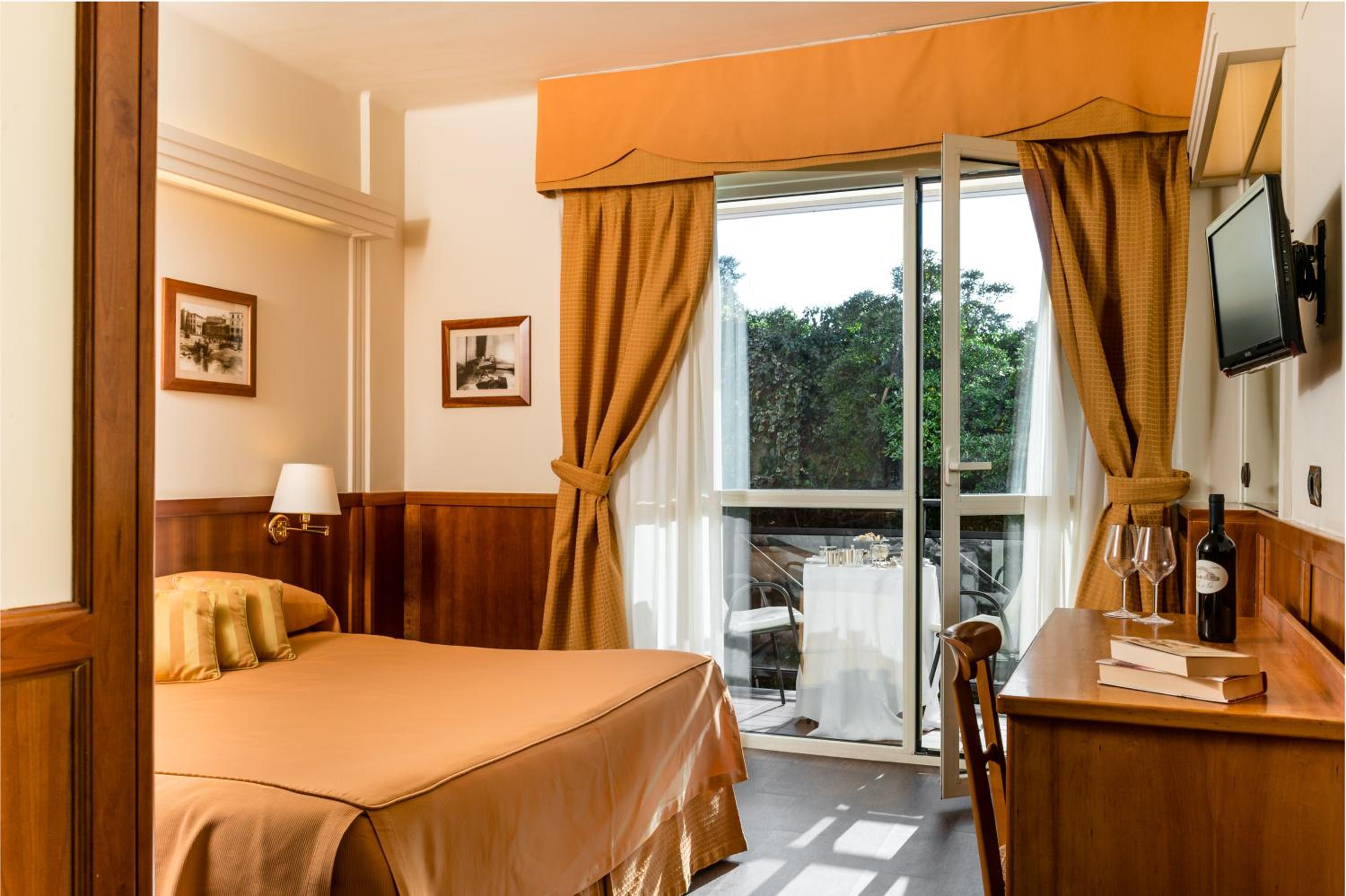 Habitación doble clásica con balcón y vista parcial al mar.