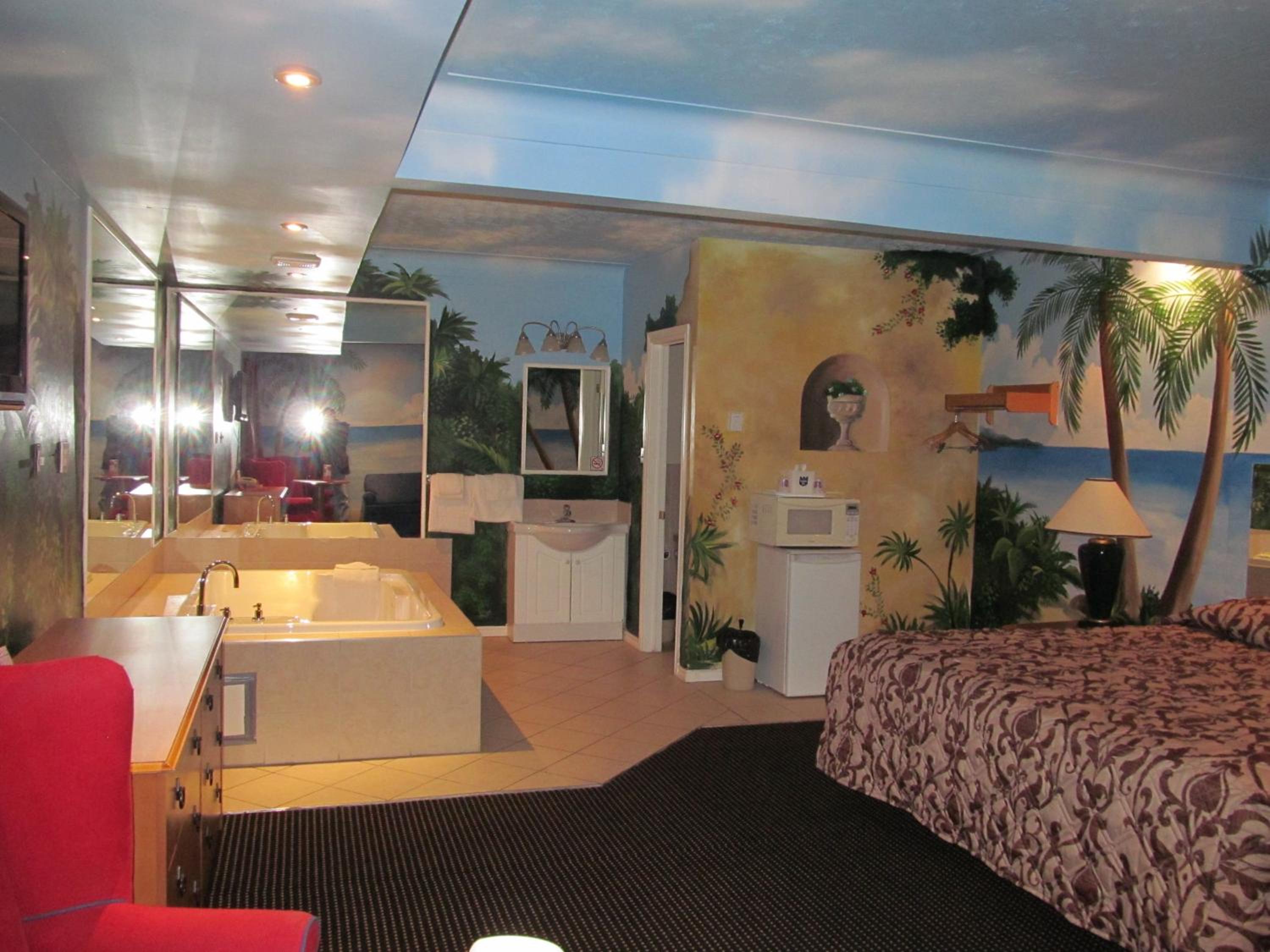 hotel room with a jacuzzi tub and palm trees