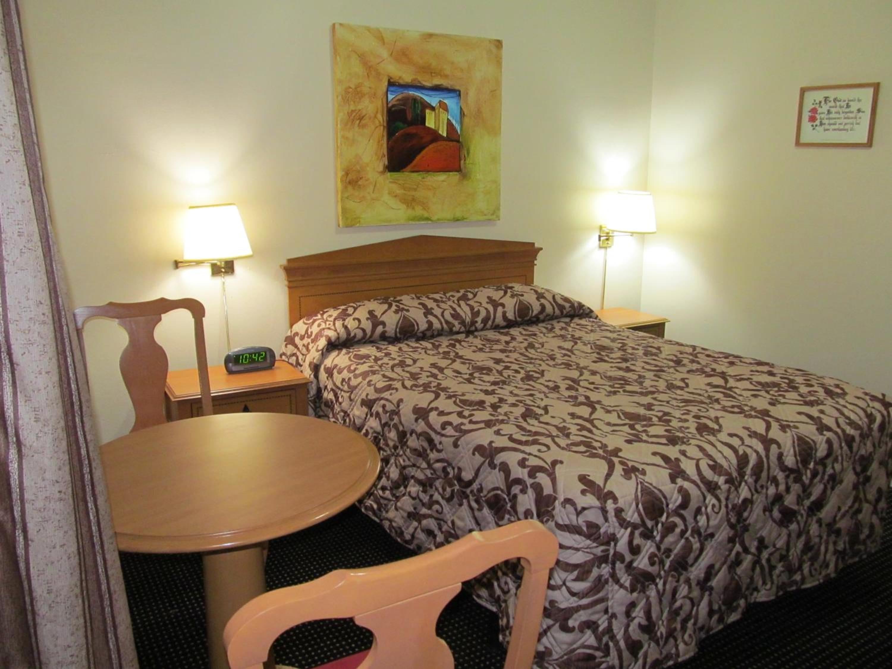 hotel room with a bed, desk, and chair