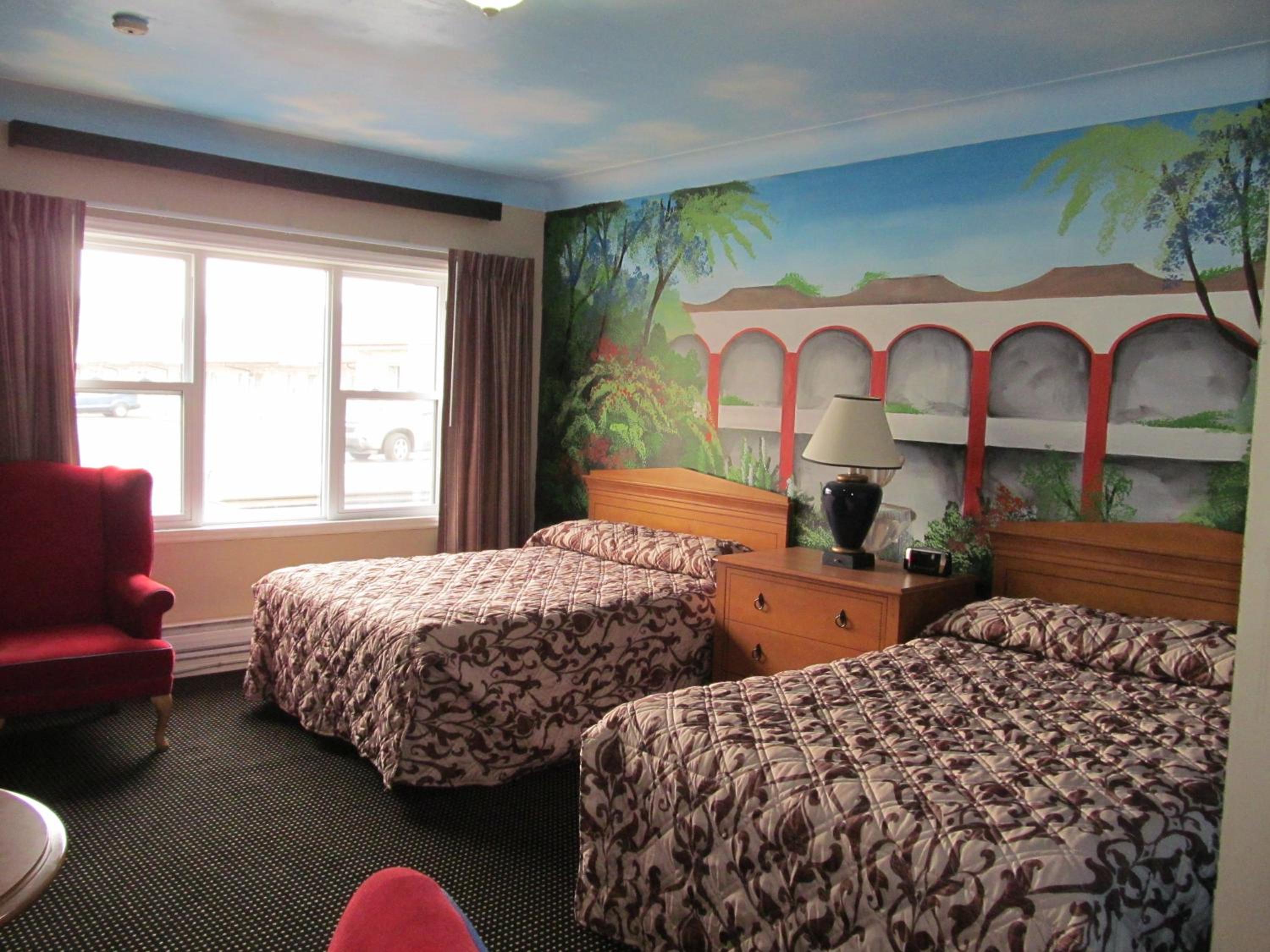 hotel room with two twin beds and a red chair