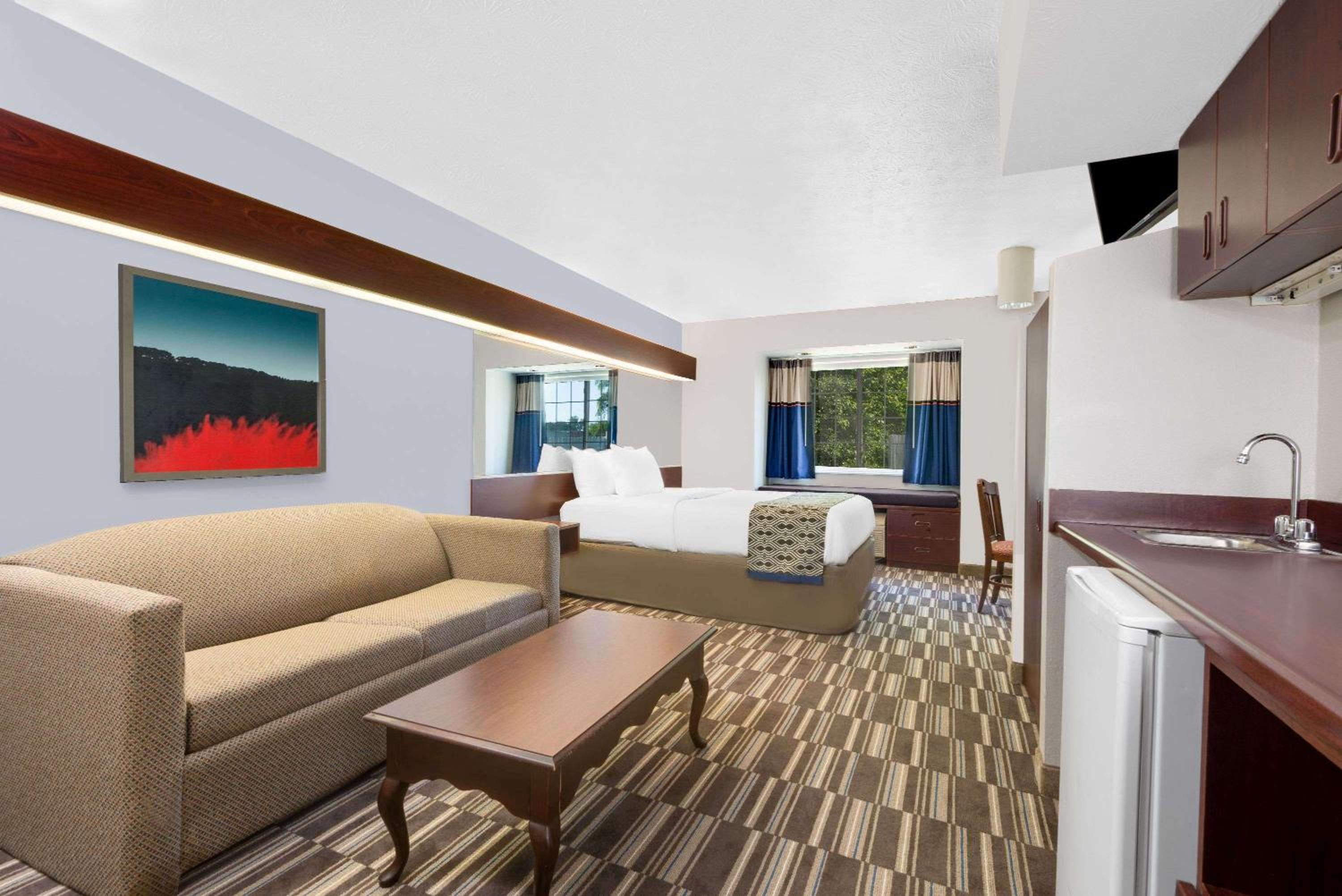 hotel room with a couch, coffee table and kitchenette
