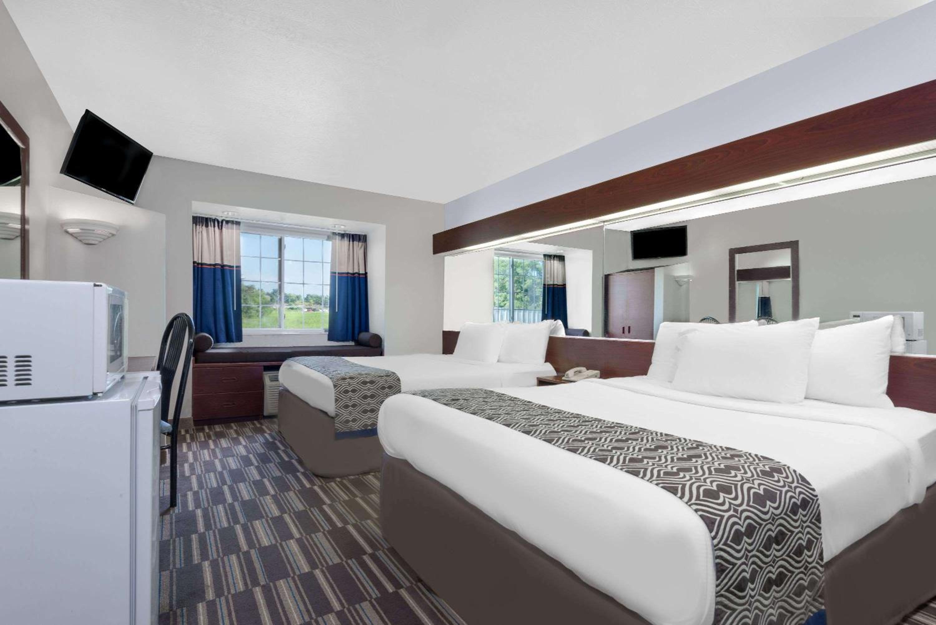 hotel room with two beds and a refrigerator in it