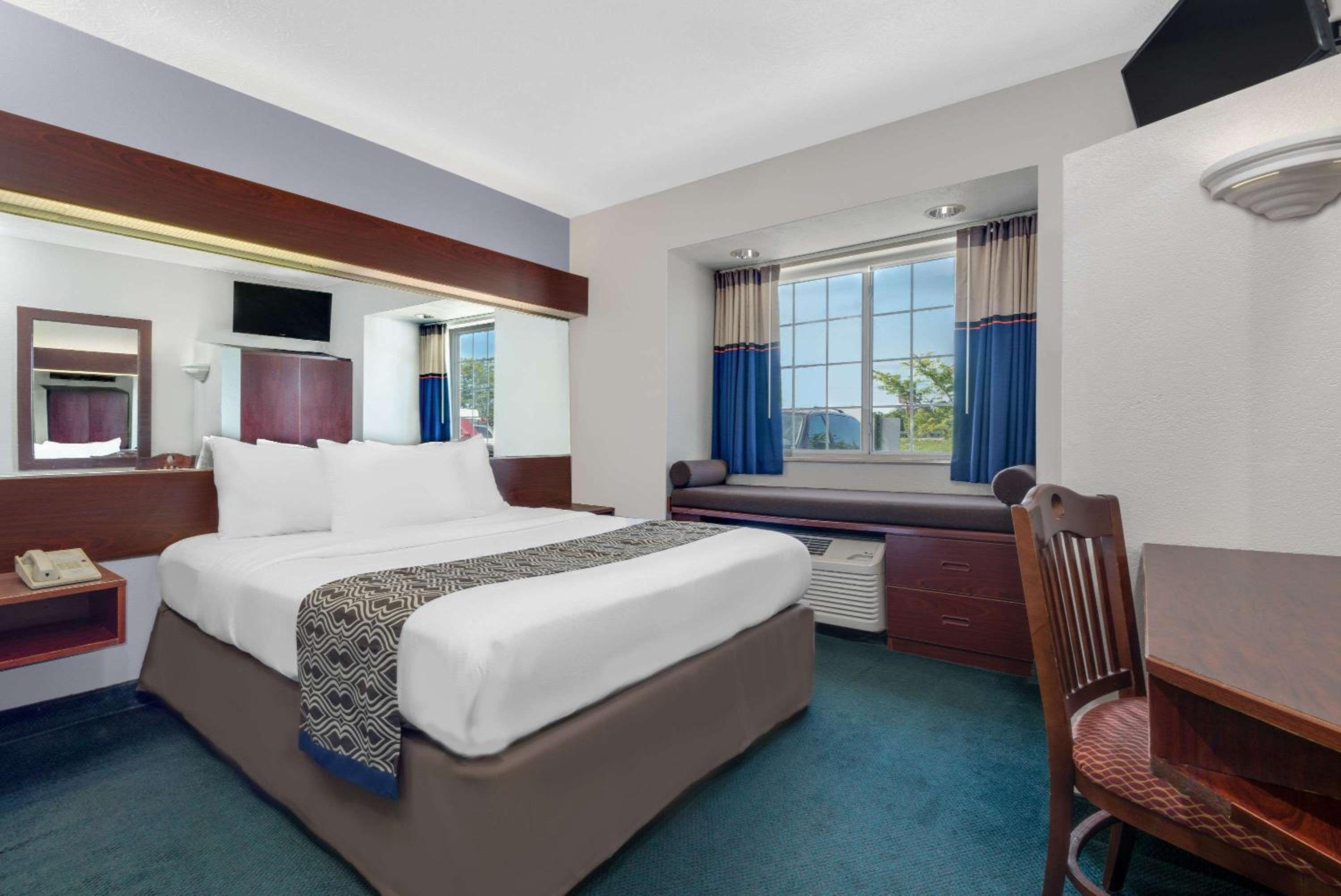hotel room with a bed, desk, and television