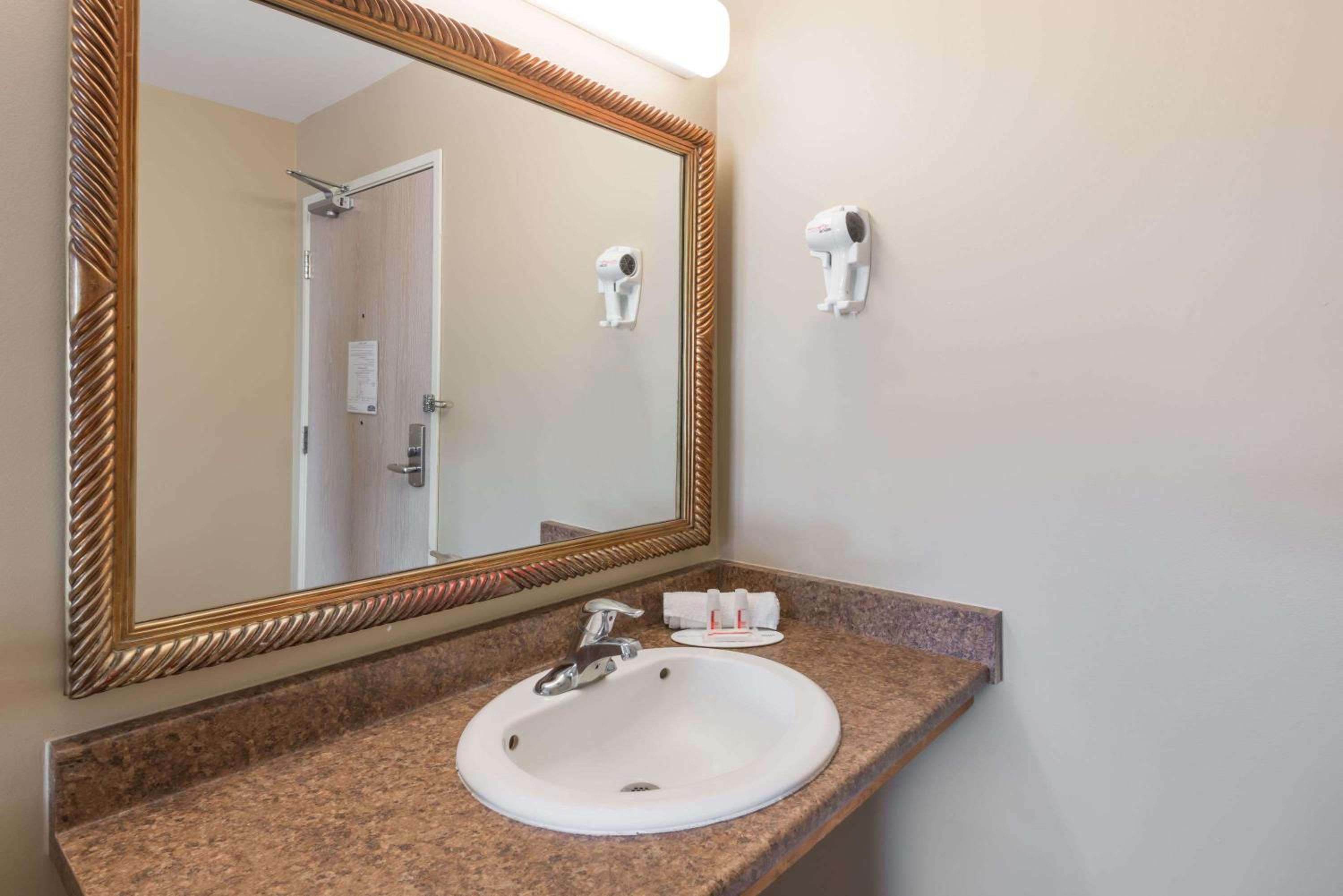 bathroom sink with a mirror and soap dispenser