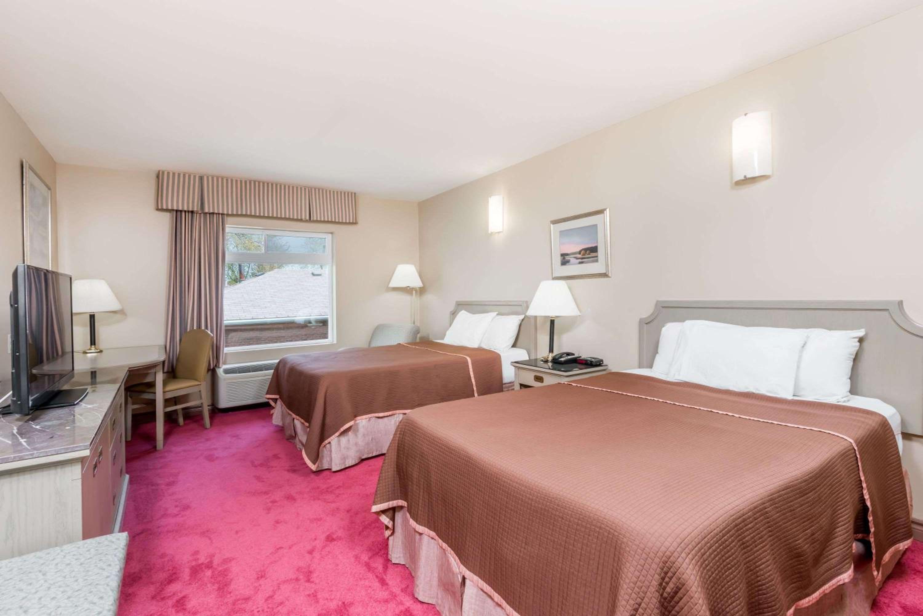 hotel room with two beds and a flat screen tv