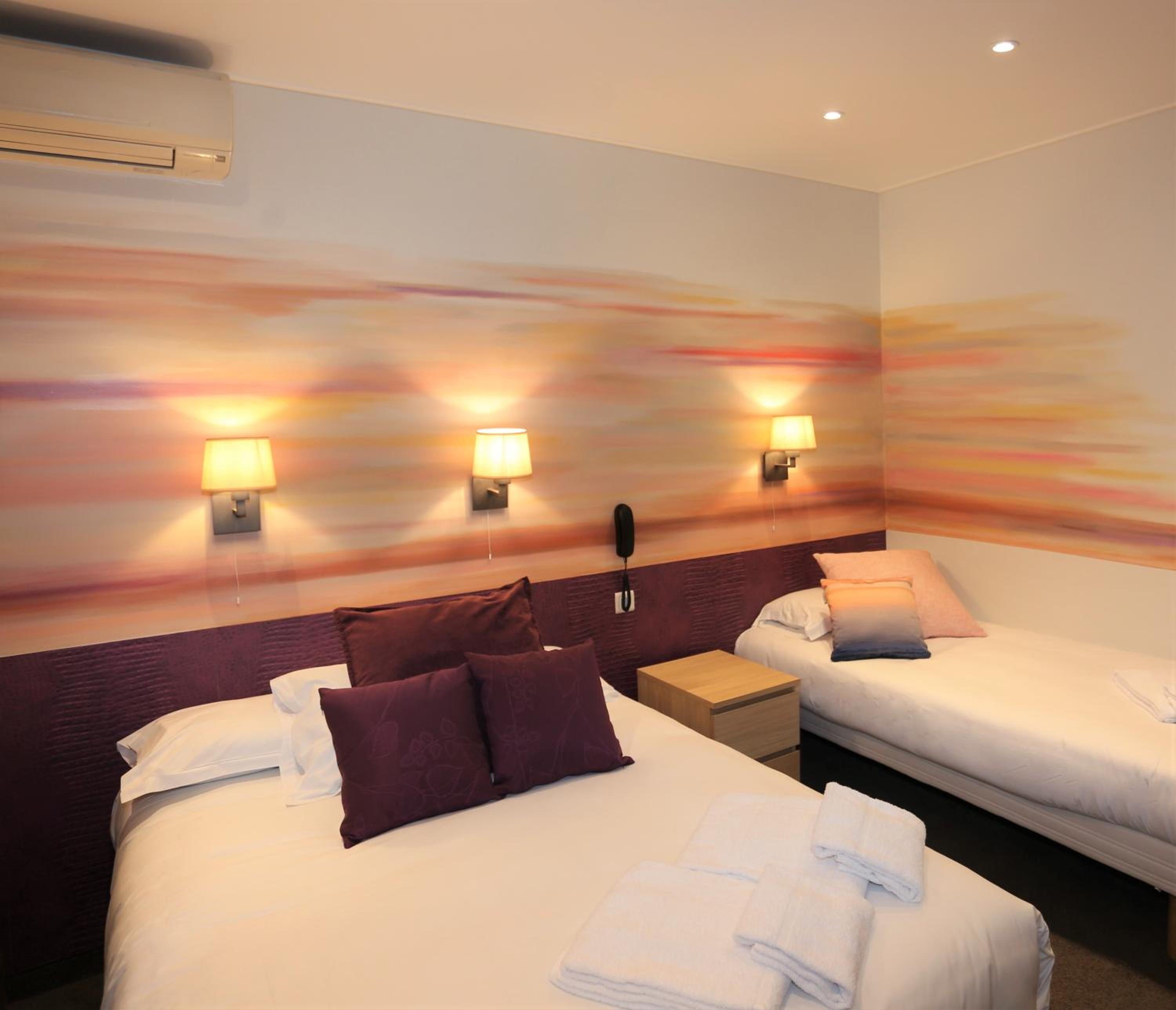 Triple Room with window overlooking a painted wall photo 1