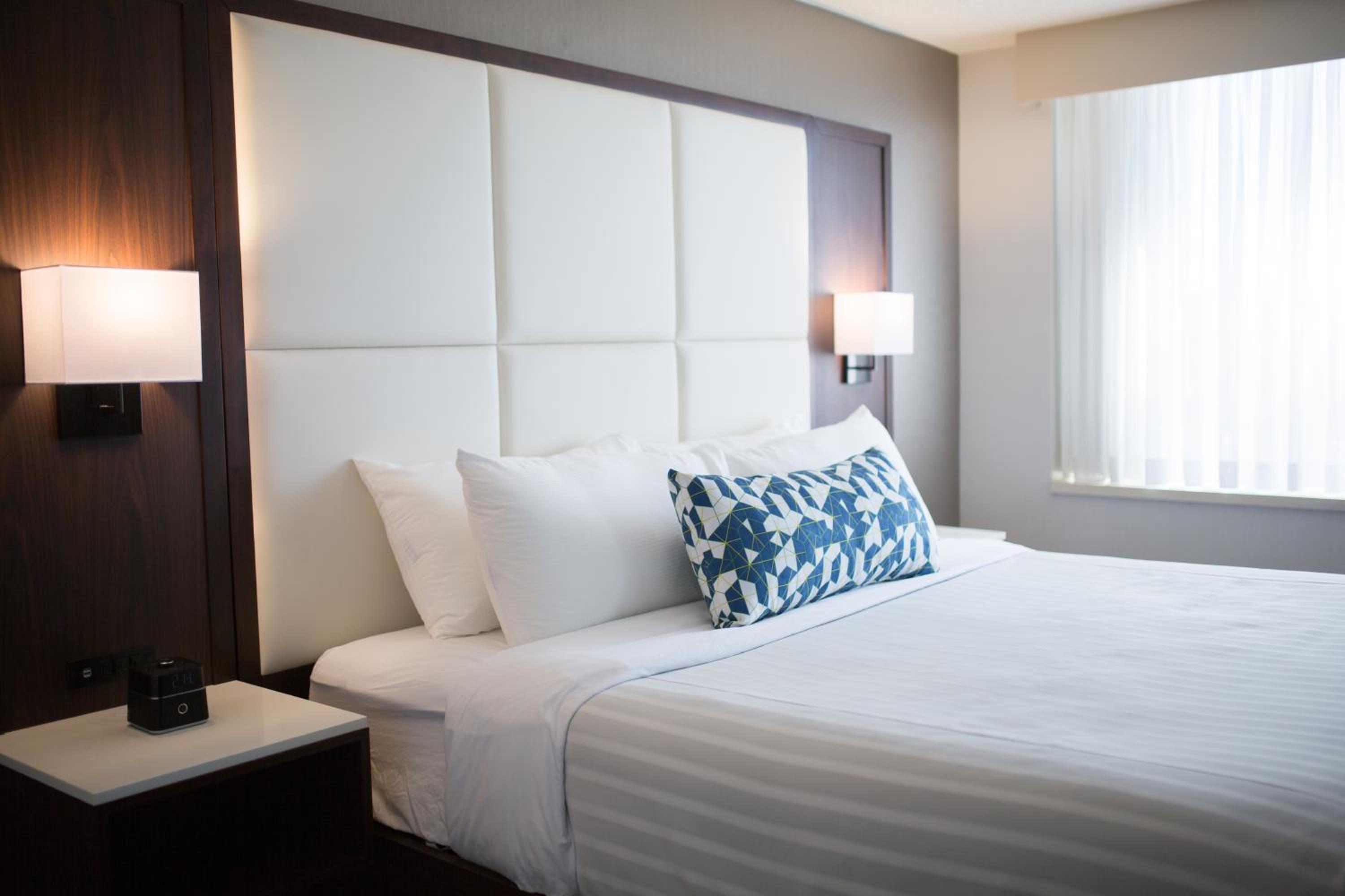 white bed with a blue and white pillow on it
