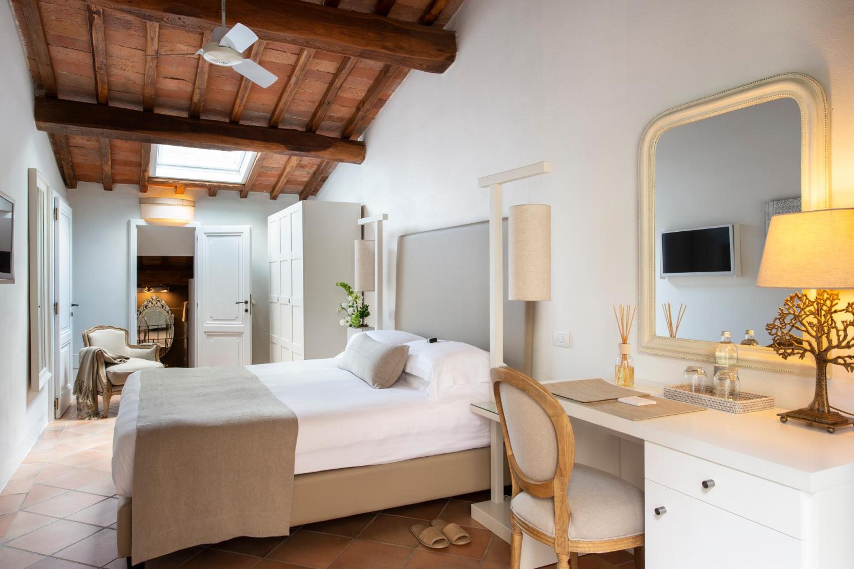 hotel room with a bed, desk, and television