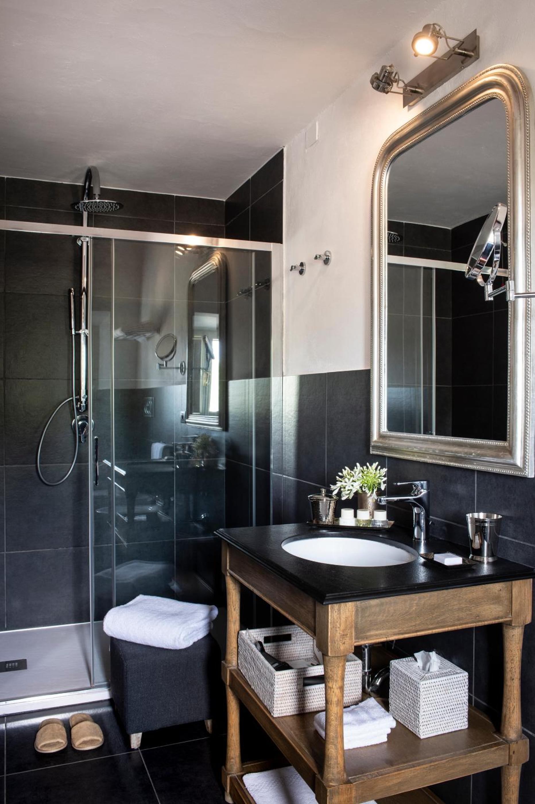 black and white bathroom with a shower, sink and toilet