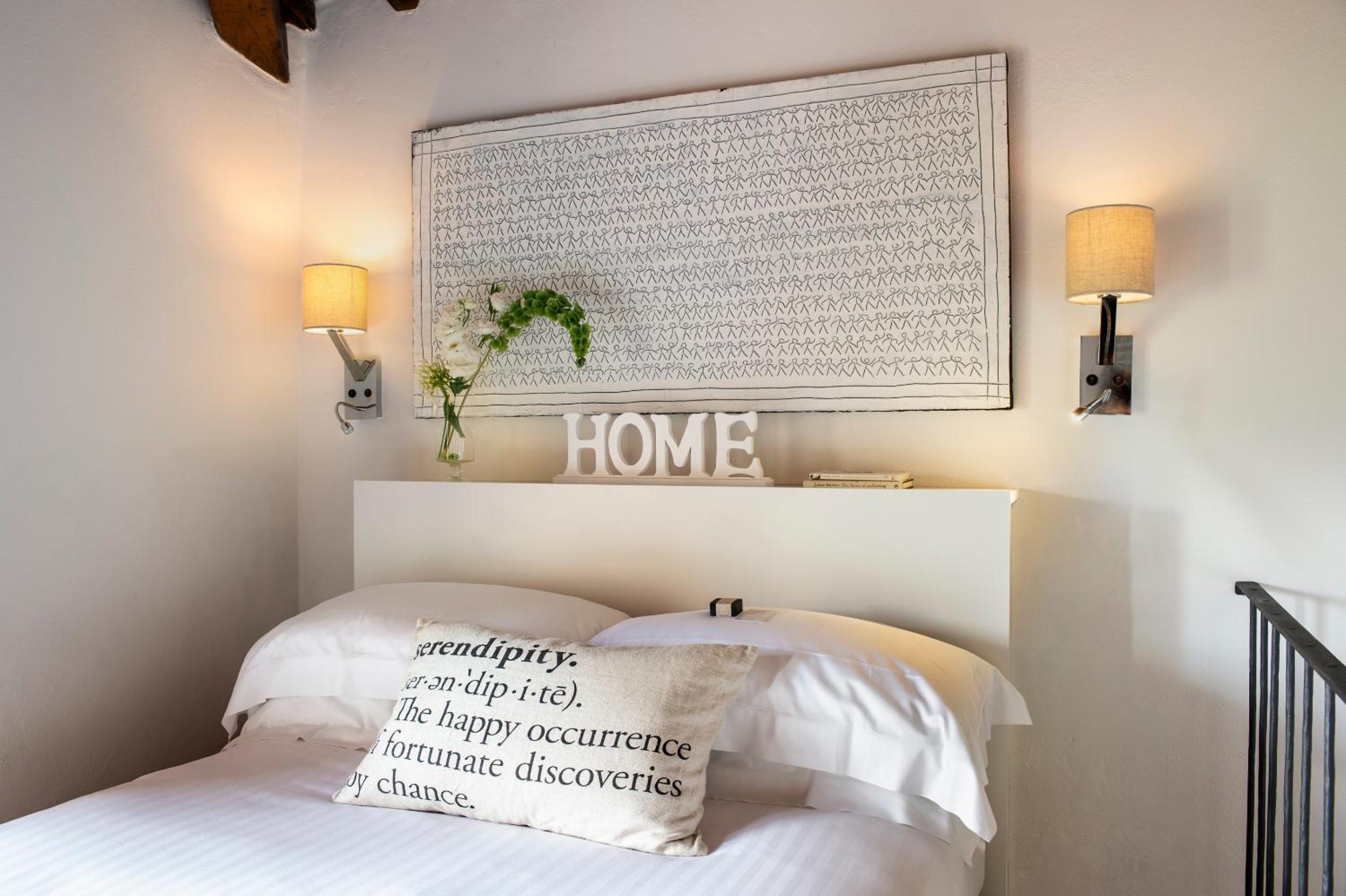 photograph of a bed with a white headboard and pillows