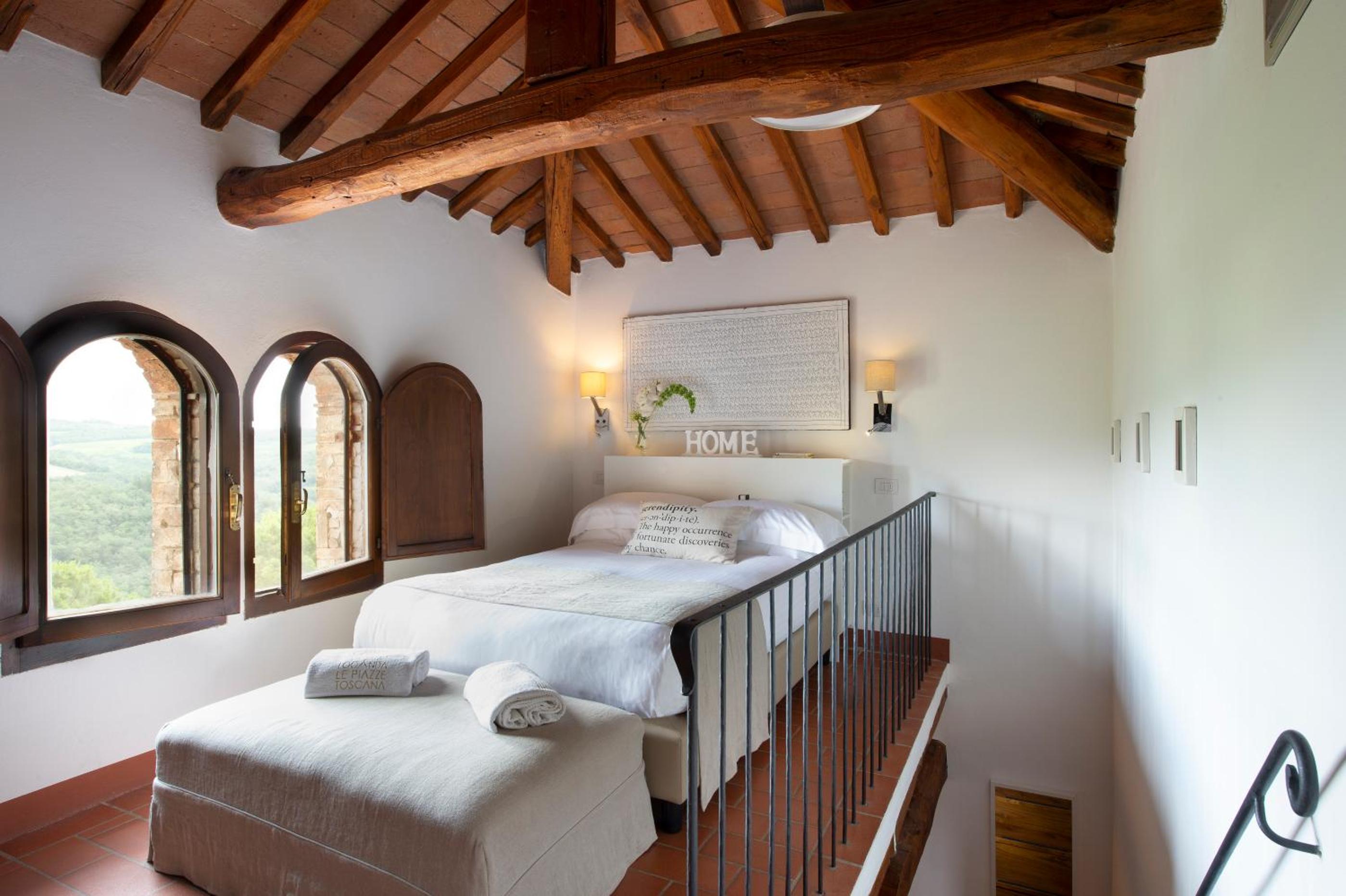 view of two beds in a room with arched windows