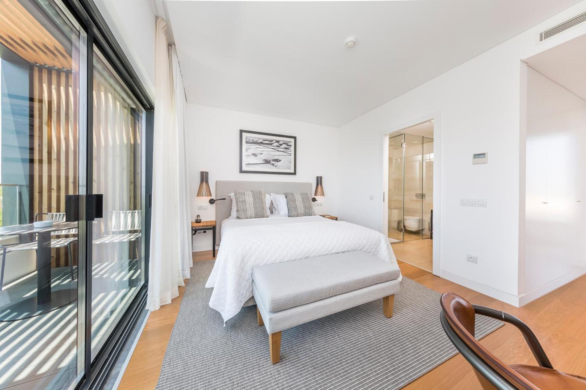 bedroom with a white bed and a large sliding glass door