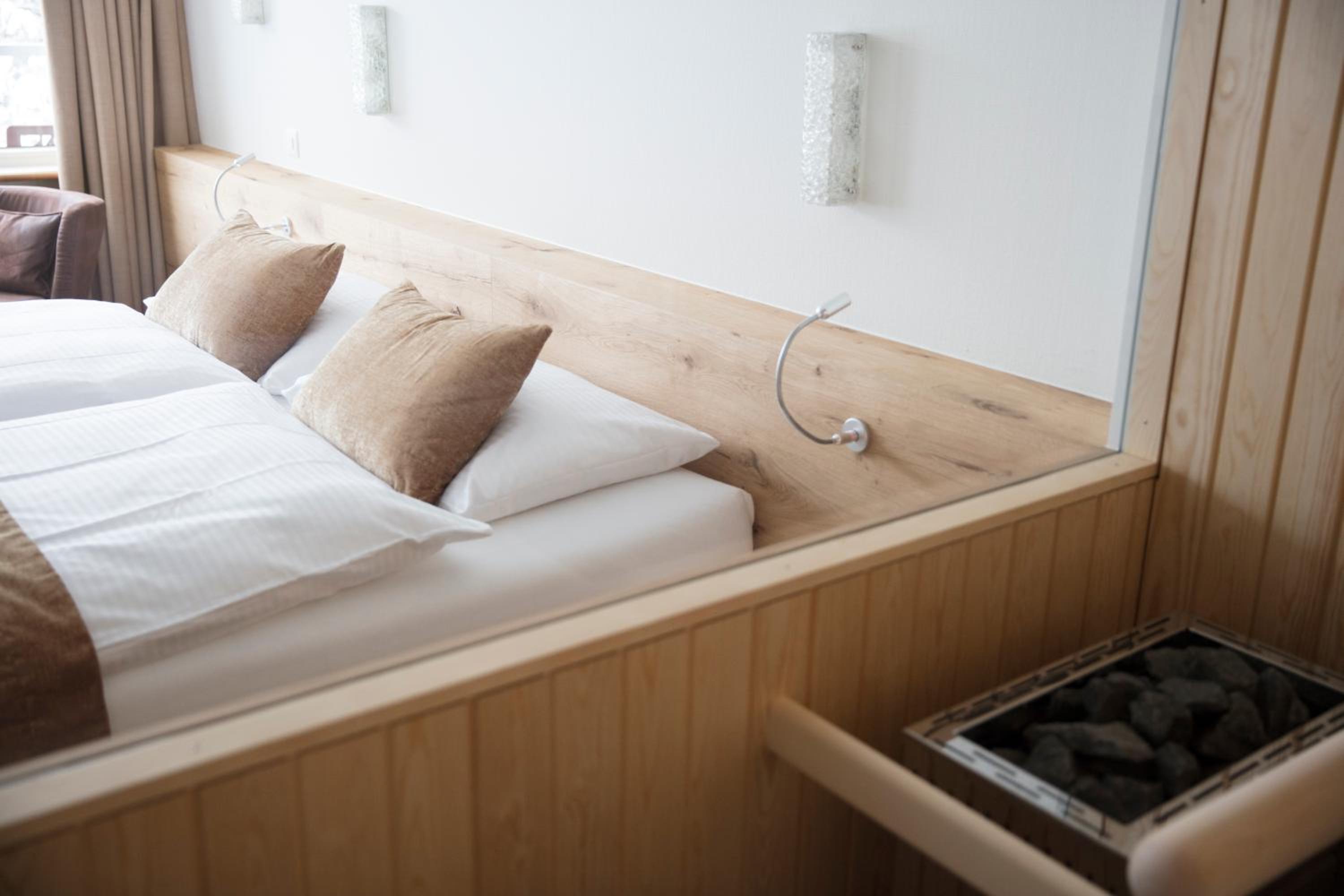 bed with two pillows and a night stand in front of it