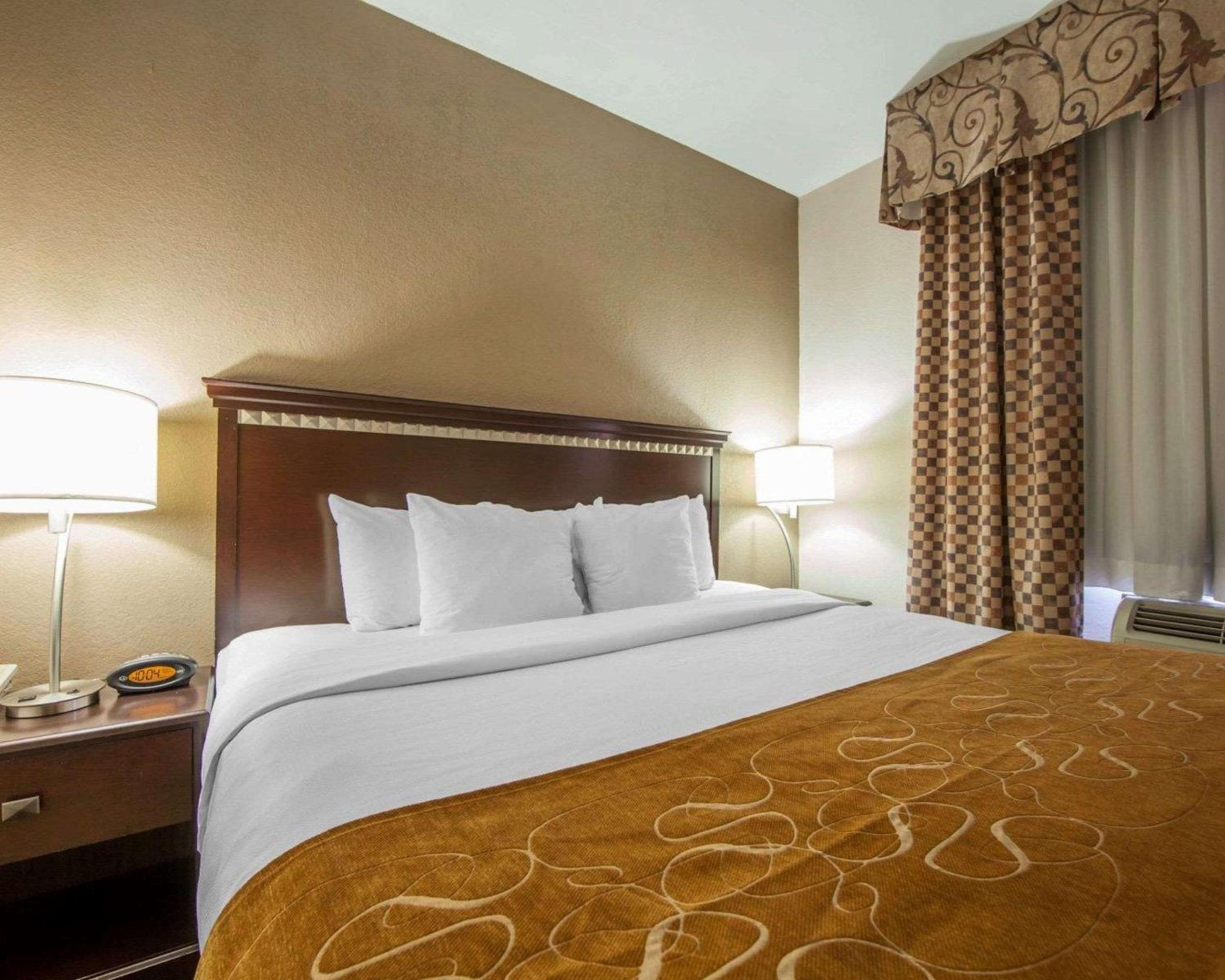 hotel room with a bed and two lamps on either side of the bed