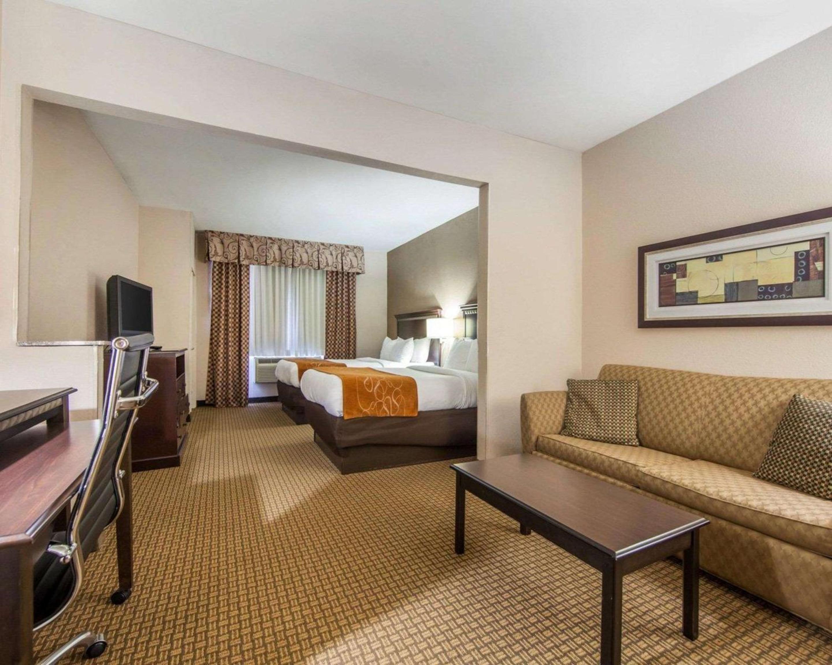 hotel room with a couch, coffee table and television