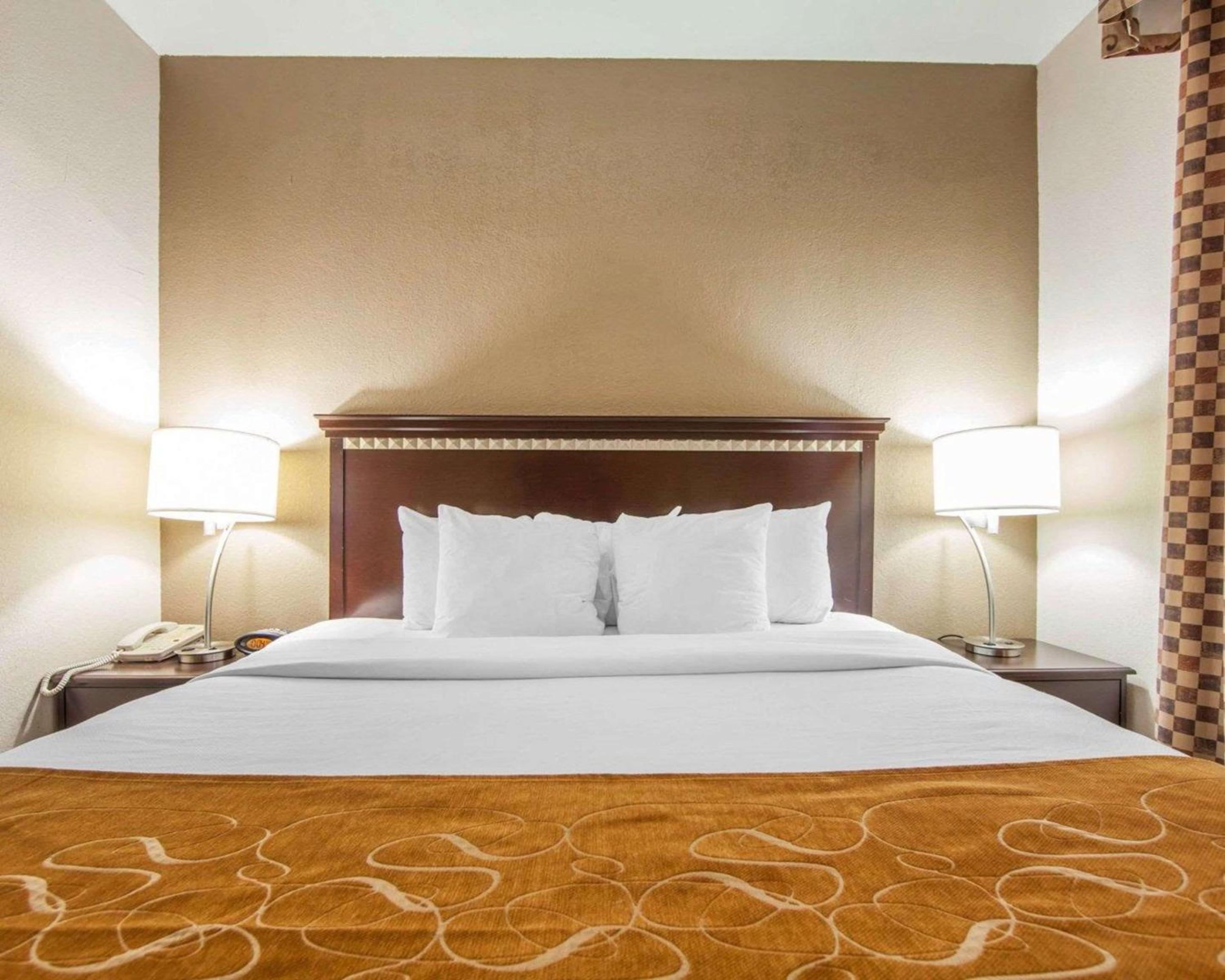 hotel room with a bed and two lamps on either side of the bed