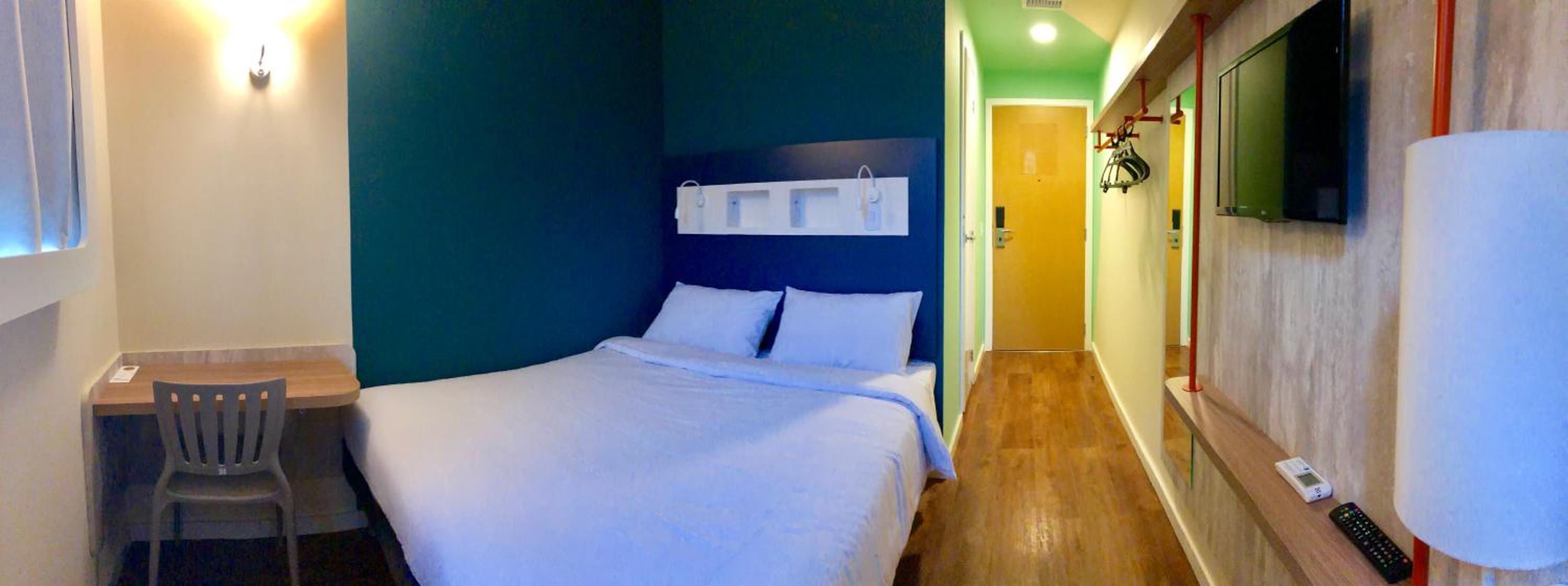 Quarto Econômico com cama casal e vista lateral cidade